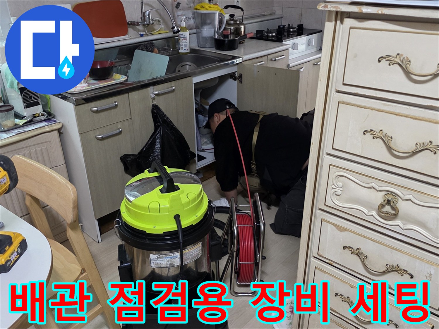 싱크대 아래 작업 공간에 배치된 습식 청소기와 전동 드릴