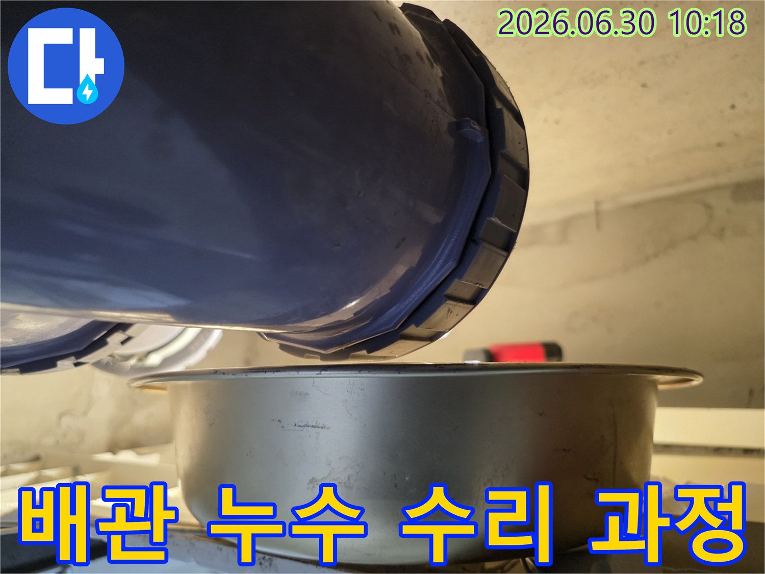 누수-현장에서-배관의-연결-부위에서-물이-새는-것을-발견하고-아래에-물받이를-놓아-누수-상황을-점검하고-수리-과정을-계획하는-모습입니다.