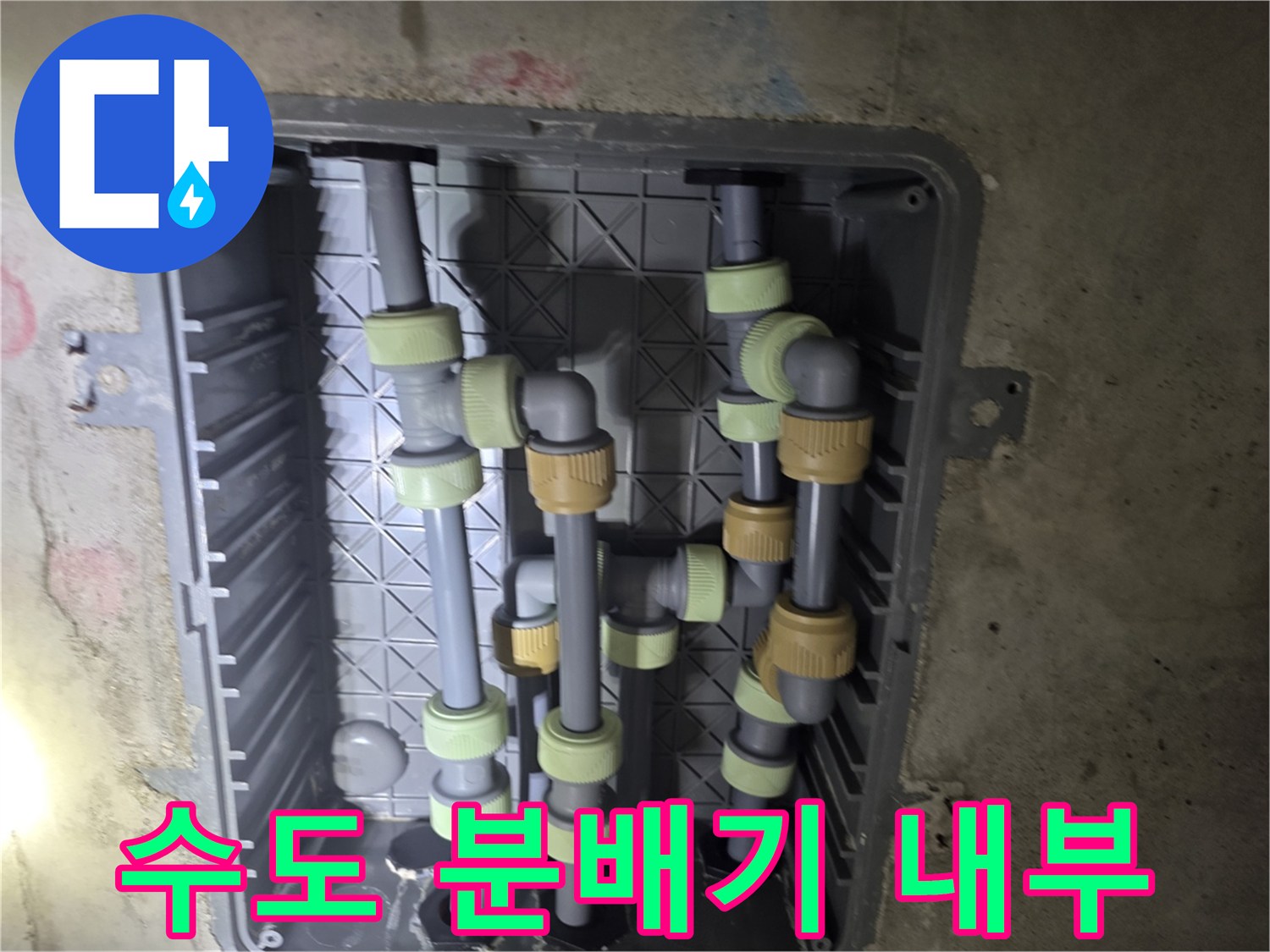 화장실 천장에 설치된 회색 배관과 연결 부품들의 모습입니다.