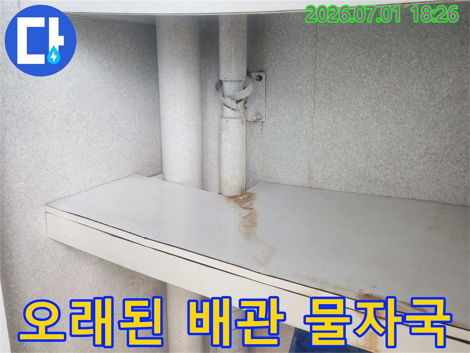 이 사진은-싱크대 하부-배관에서-발생한 누수로 인해-주변 패널에-생긴-녹슨 물 자국을-명확하게 보여줍니다