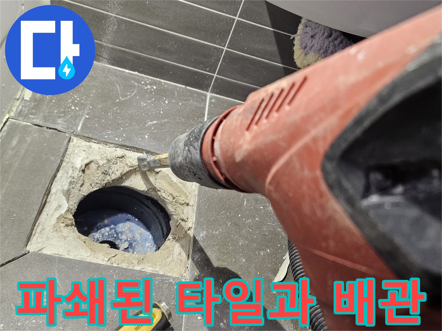 타일을 걷어낸 후 드러난 하수구 배관과 주변의 파쇄된 잔해입니다.