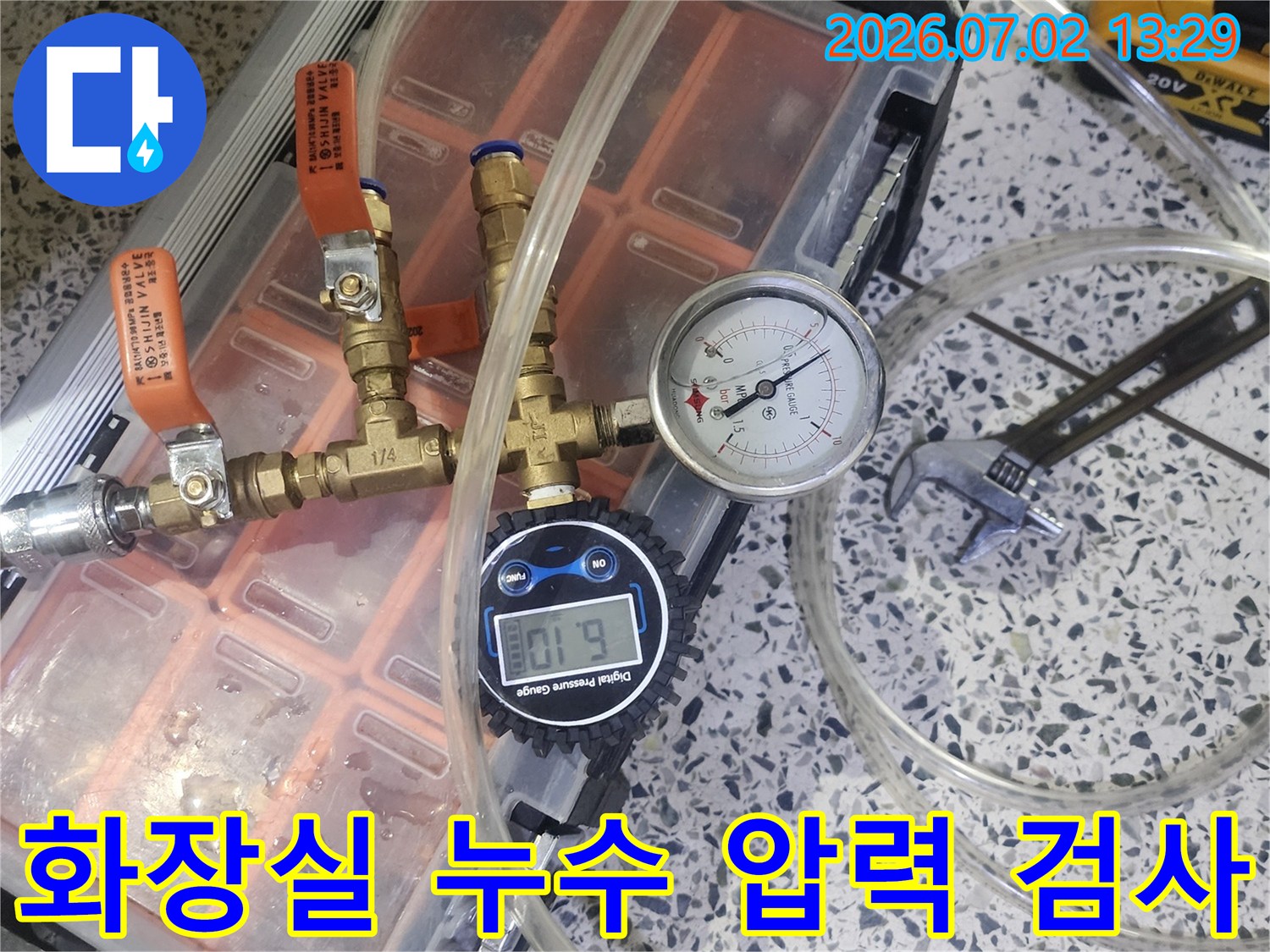 화장실 배관의 누수 여부를 확인하기 위해 압력 게이지가 연결된 전문 테스트 장비를 사용하고 있습니다