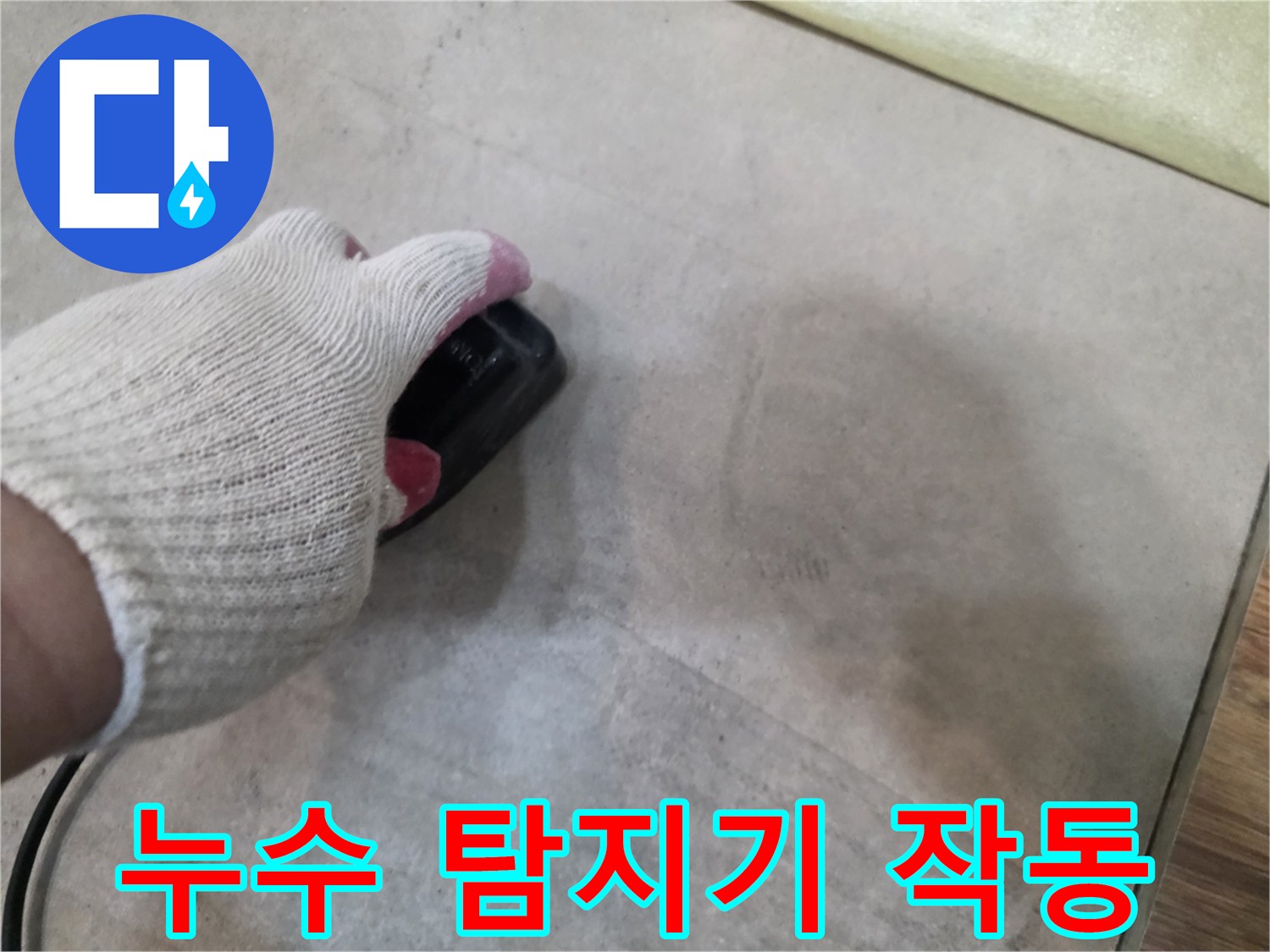 장갑을 낀 손이-바닥재 위에서-정밀 누수 탐지기를 조작하는 모습