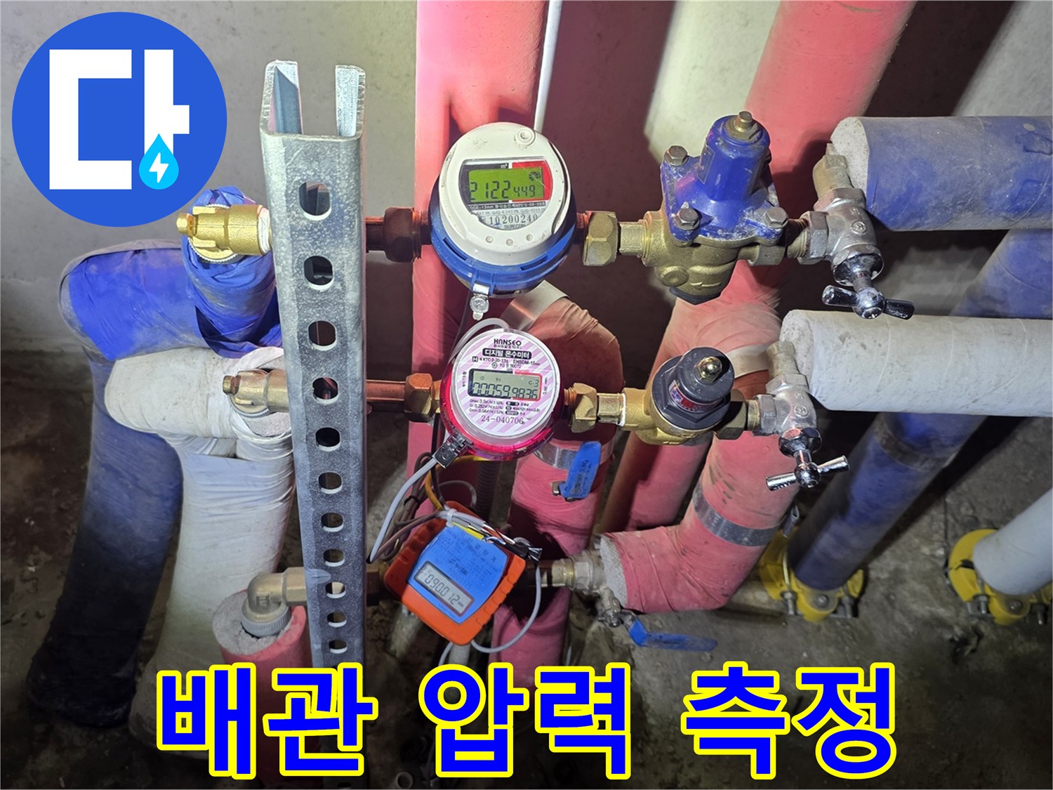 보온재로 감싸진 배관에 연결된 압력 검사 장비의 모습