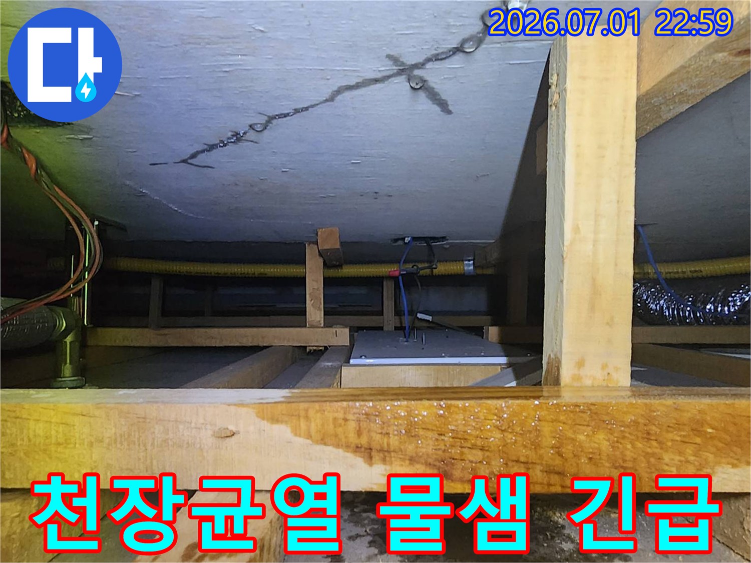 천장 균열에서 물이 새어-젖은 목재 구조물을-보여주는-긴급 누수 조치 현장입니다.