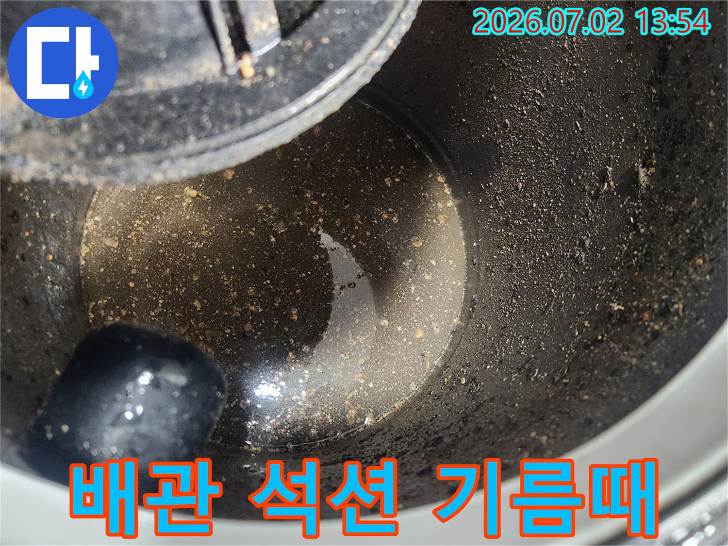 배관 스케일링 1차 작업 후-석션 장비로 제거된-굳은 기름때와 슬러지 상태를 보여주는 사진