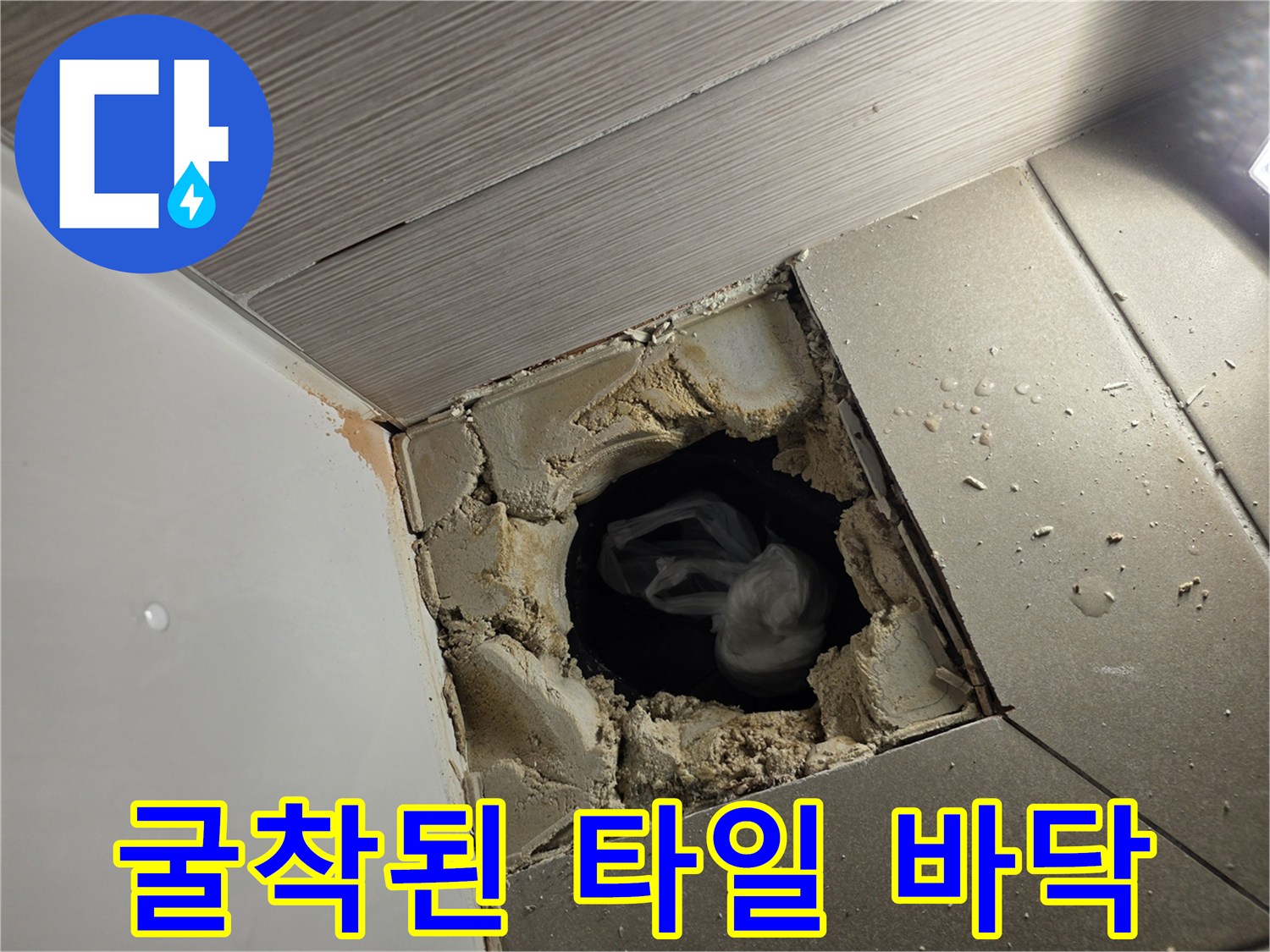 배수구 주변의 타일과 시멘트가 제거된 굴착 현장