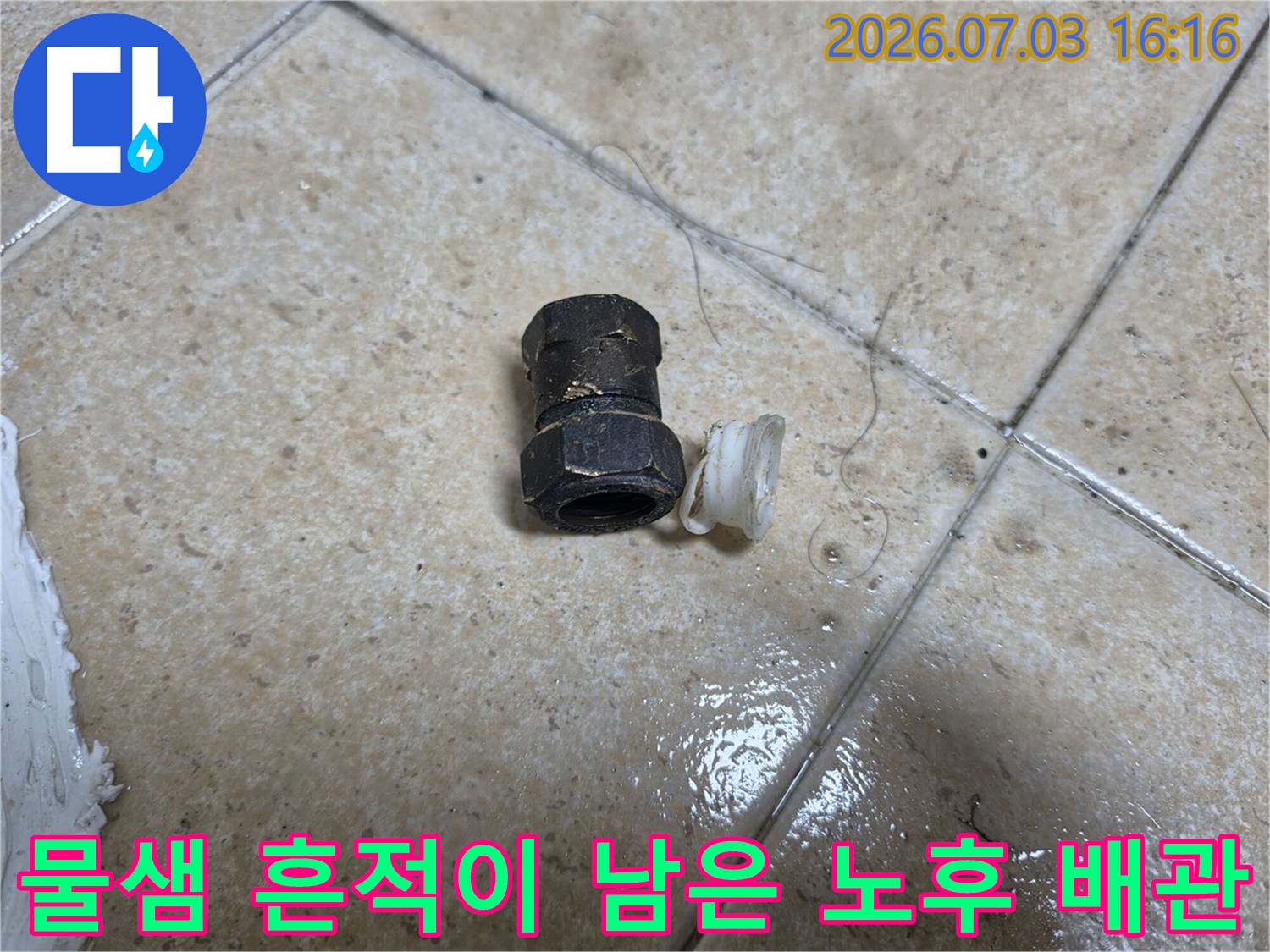 세면대 하단에 위치한 파손된 배관 연결 부품 사진