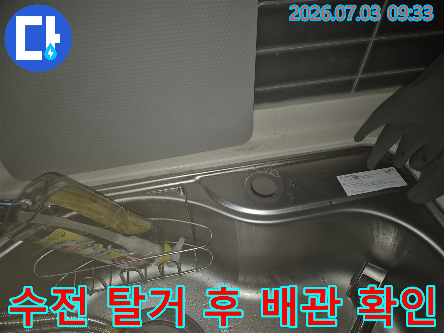 탈거된 수전 자리에 노출된 싱크대 배관 및 연결부