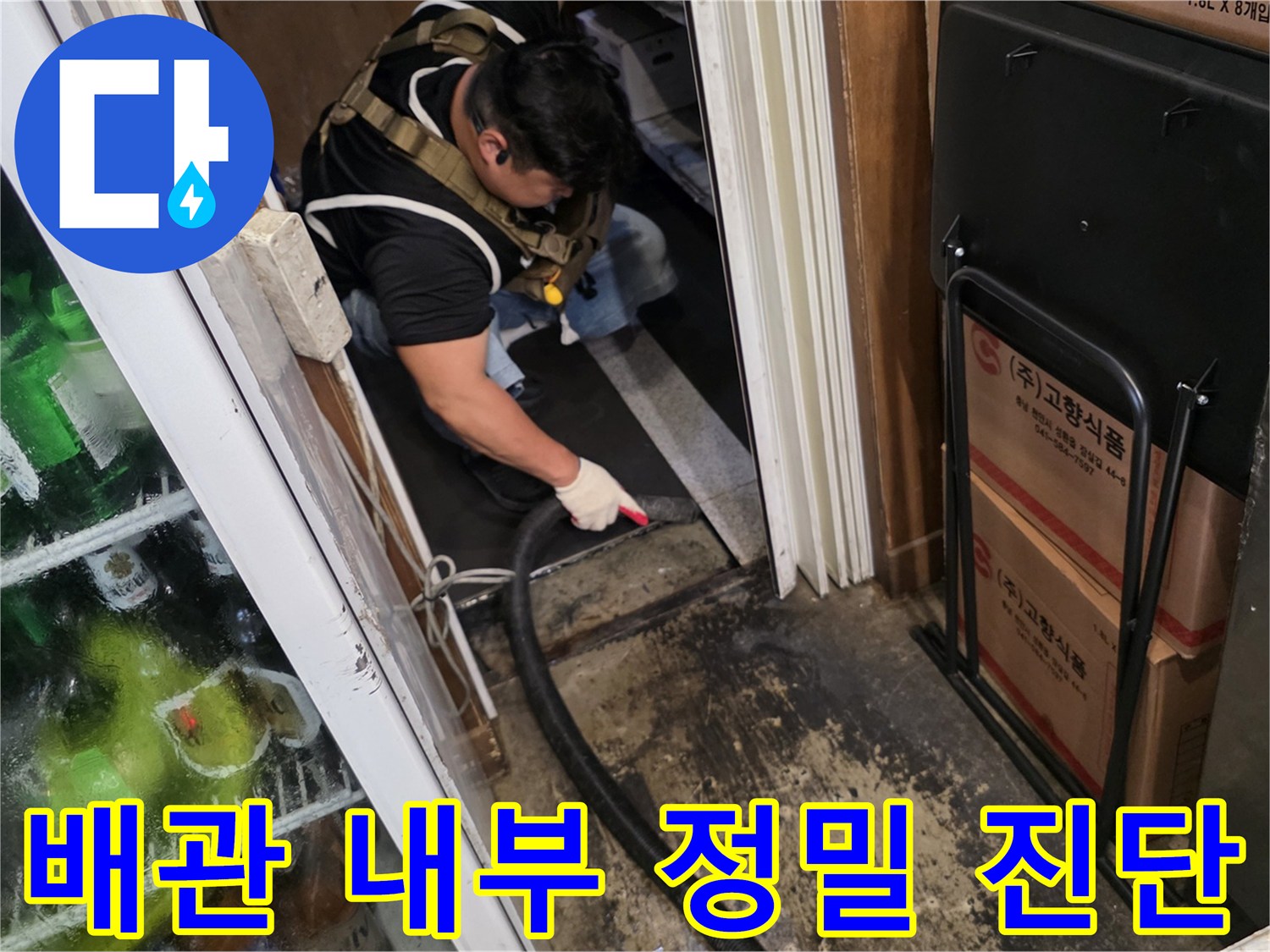 작업자가 좁은 공간의 배관 연결부를 세밀하게 관찰하고 있습니다.