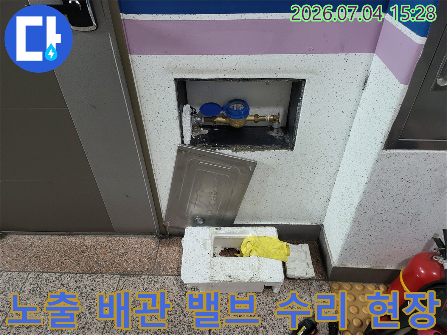 파란색 밸브가 달린 계량기 함 내부의 노출된 수도 배관 교체 작업