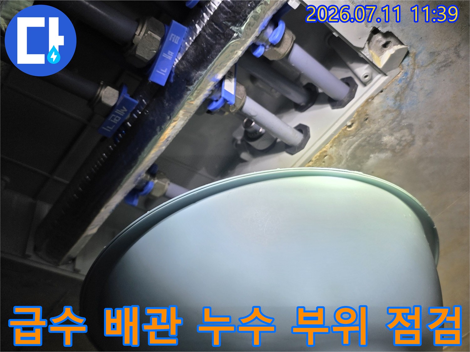 파란색 덮개로 보호된 급수 배관과 밸브 연결부의 확대 사진