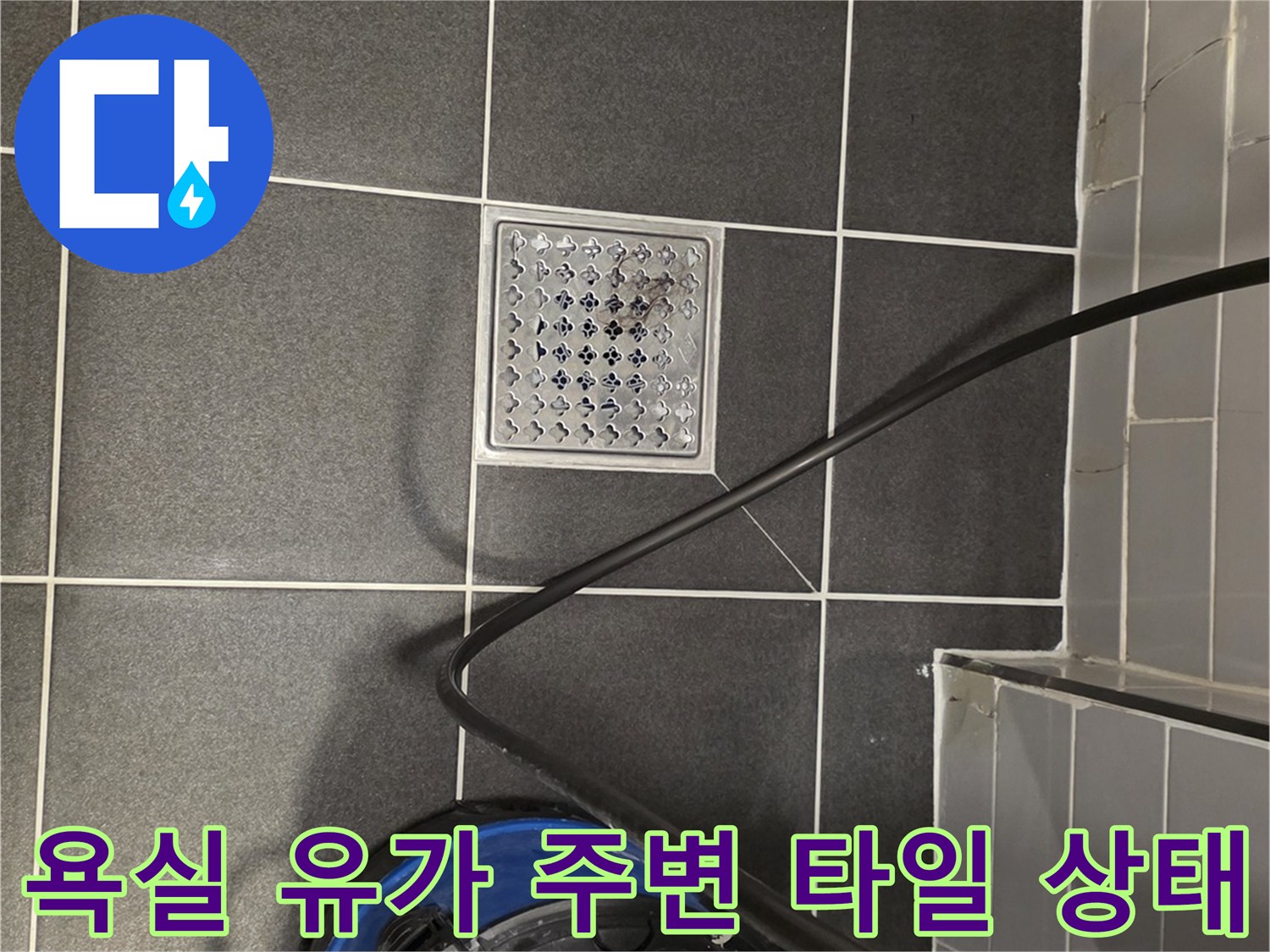 타일 바닥에 설치된 금속제 배수구 덮개와 주변 청소 장비