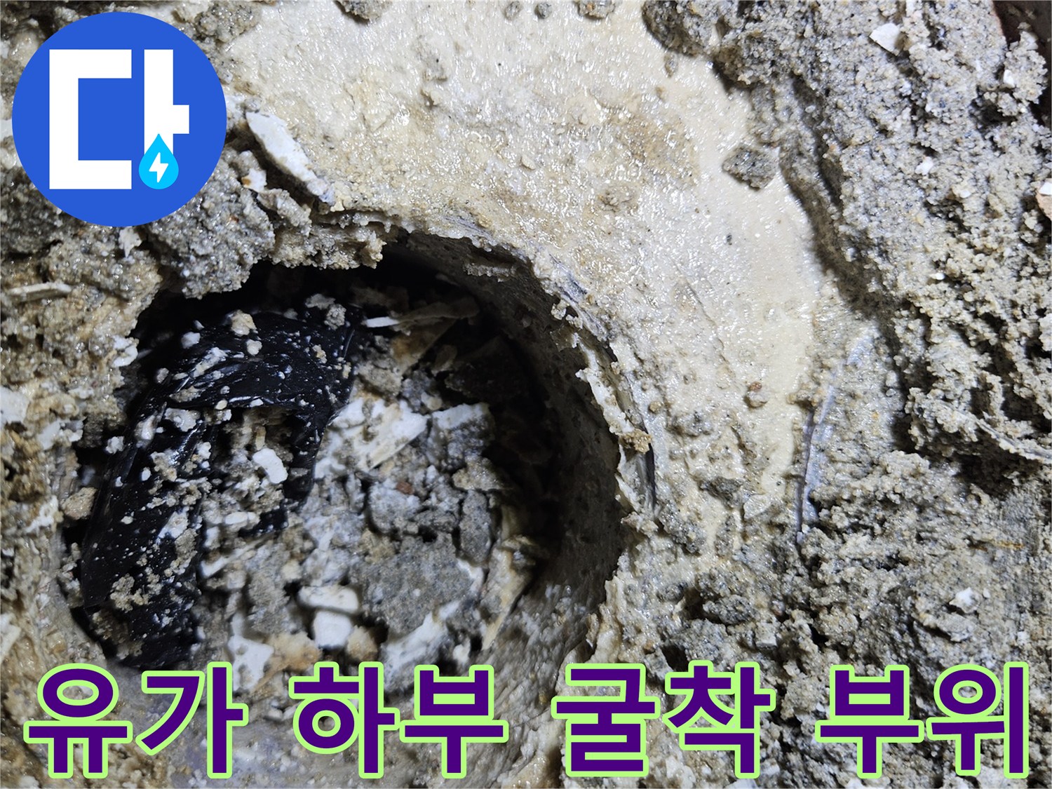 욕실 배수구-주변의 노출된 배관과 깨진 시멘트층
