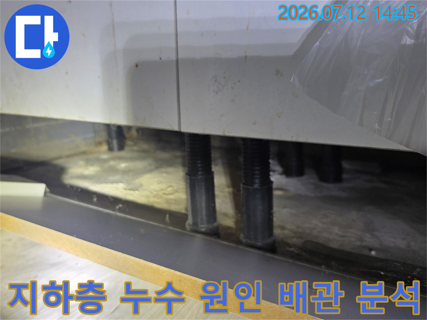 싱크대 하부 공간에서 노출된 배관들의 상태를 점검하며 누수 경로를 파악하는 사진
