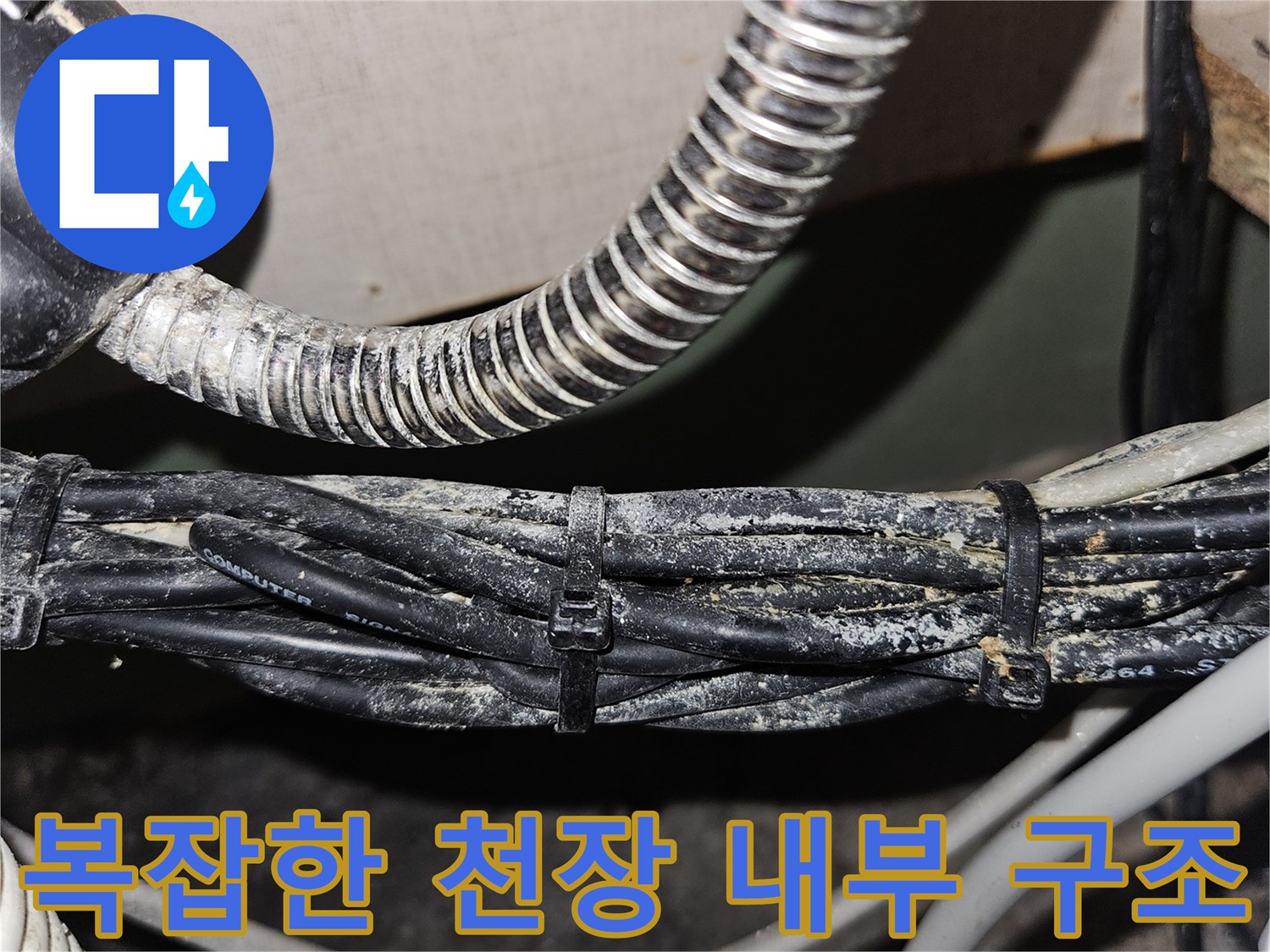 천장 안쪽의 은색 주름관과 검은 전선들이 얽혀 있는 현장 사진입니다.