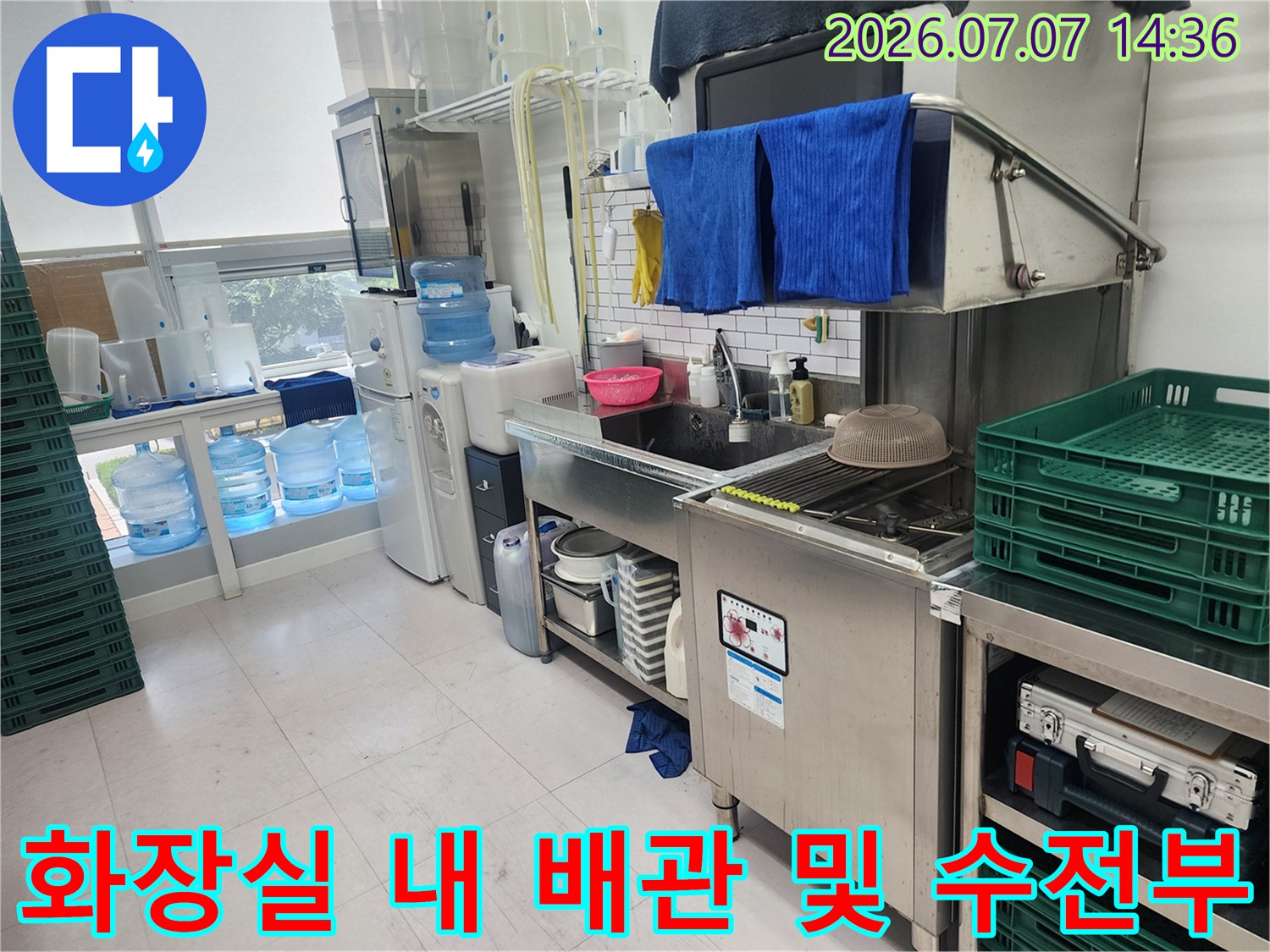 스테인리스 소재의 세면대와 배관이 설치된 실내 공간