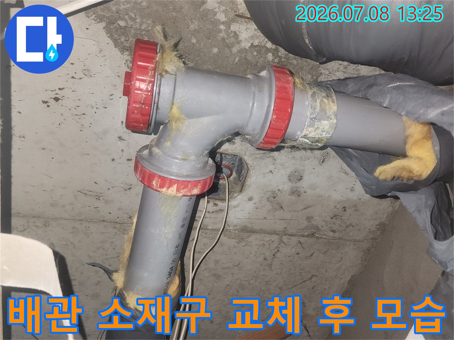 붉은색 마감재가 씌워진 하수 배관 연결 부위 사진