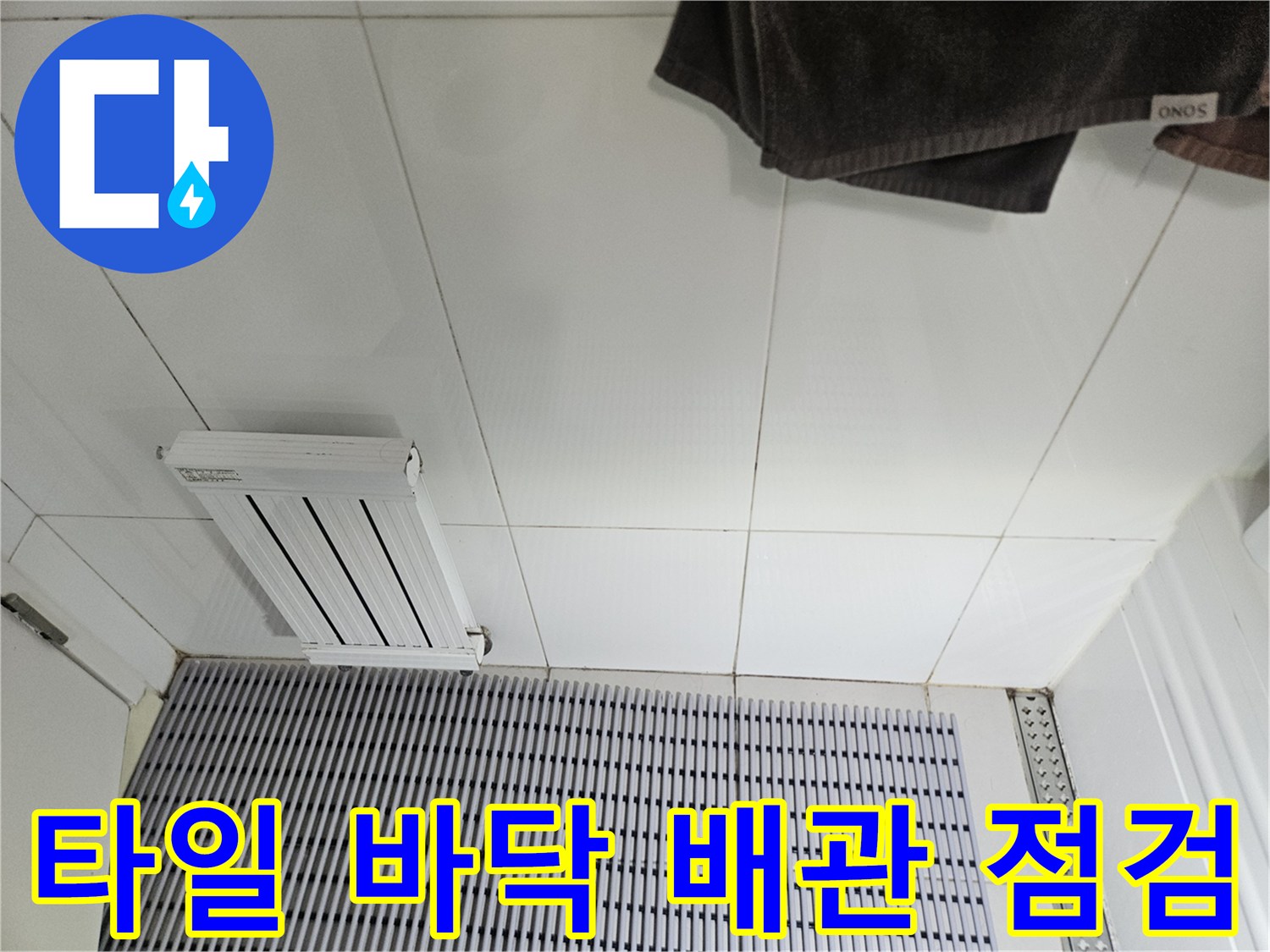 하얀색 타일 바닥에 놓인 에어컨 배관 부속품과 환풍구 모습