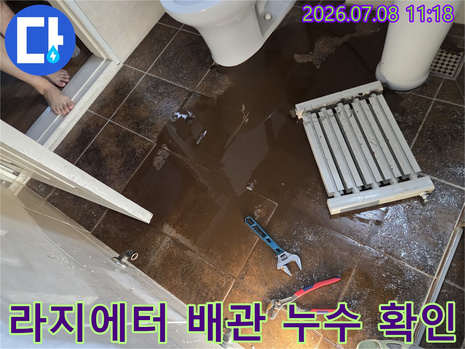 누수된 라지에터 배관을 철거하고 공구를 배치한 화장실 수리 현장