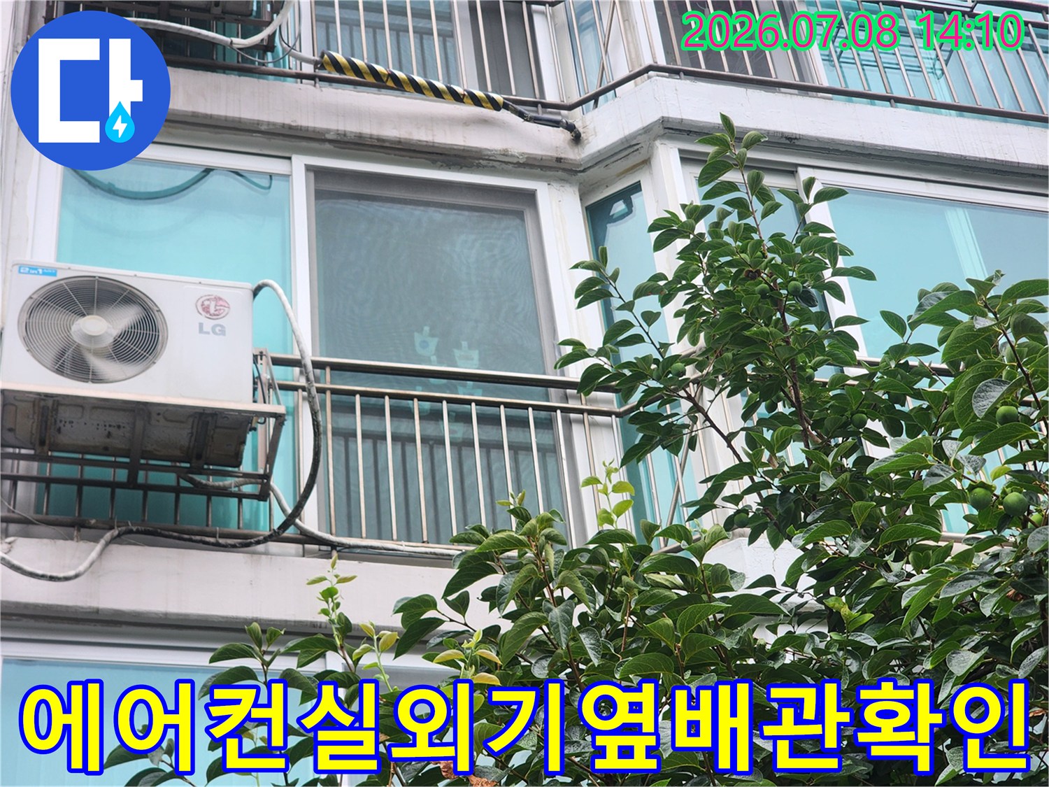 에어컨 실외기 옆으로 노출된 배관과 창문이 있는 베란다 외벽 모습