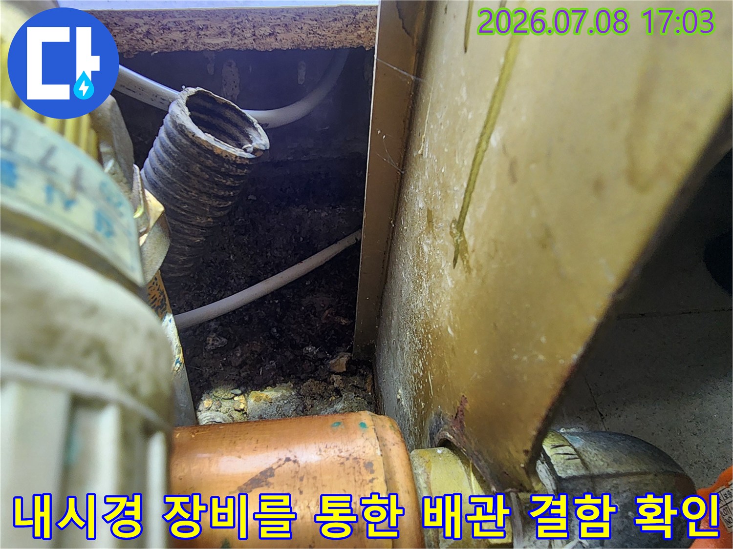 싱크대 하부의 복잡한 배관 구조를 내시경으로 촬영하여 누수 지점을 식별하는 장면