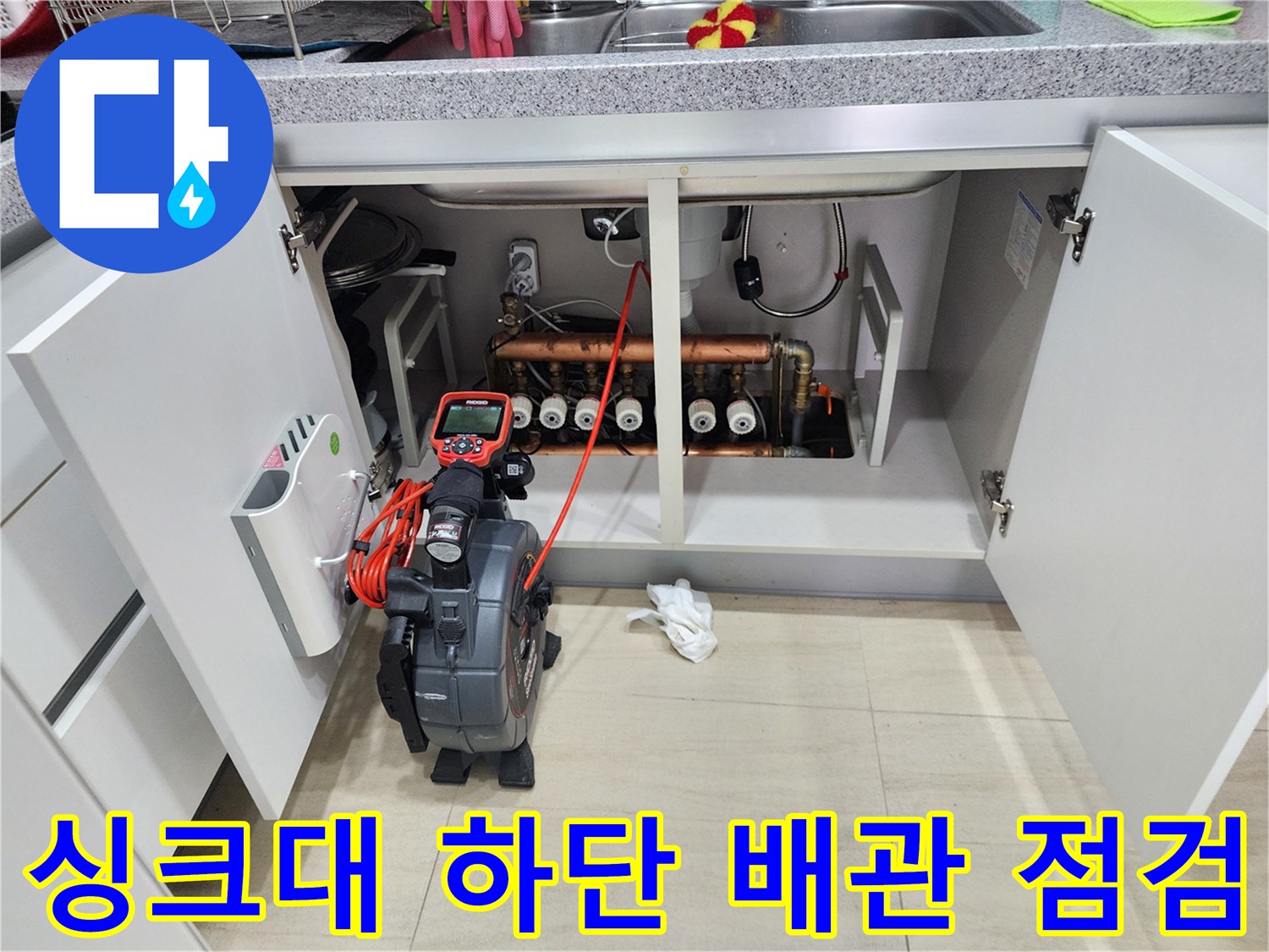싱크대 하부장 내 배관과 내시경 모니터링 장비의 현장 모습