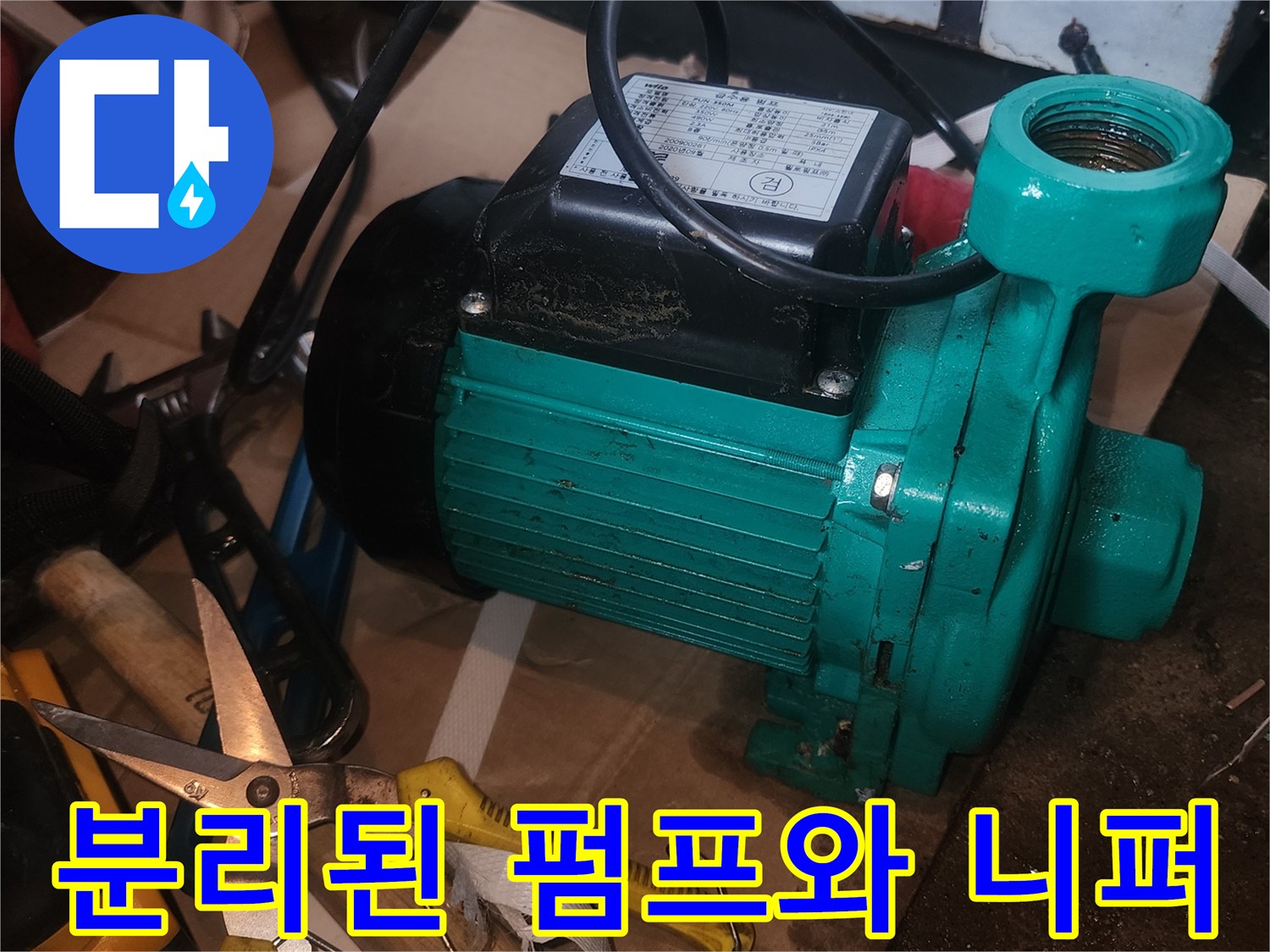 작업 현장에 놓인 초록색 펌프와 노란색 공구 세트