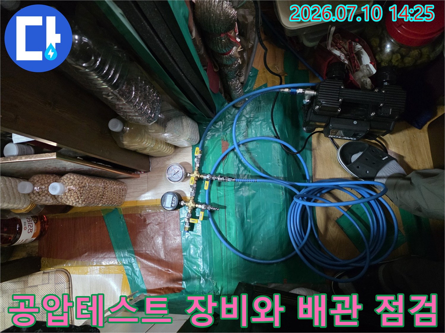 기계식 압력 게이지와 파란색 호스가 연결된 누수 탐지 현장