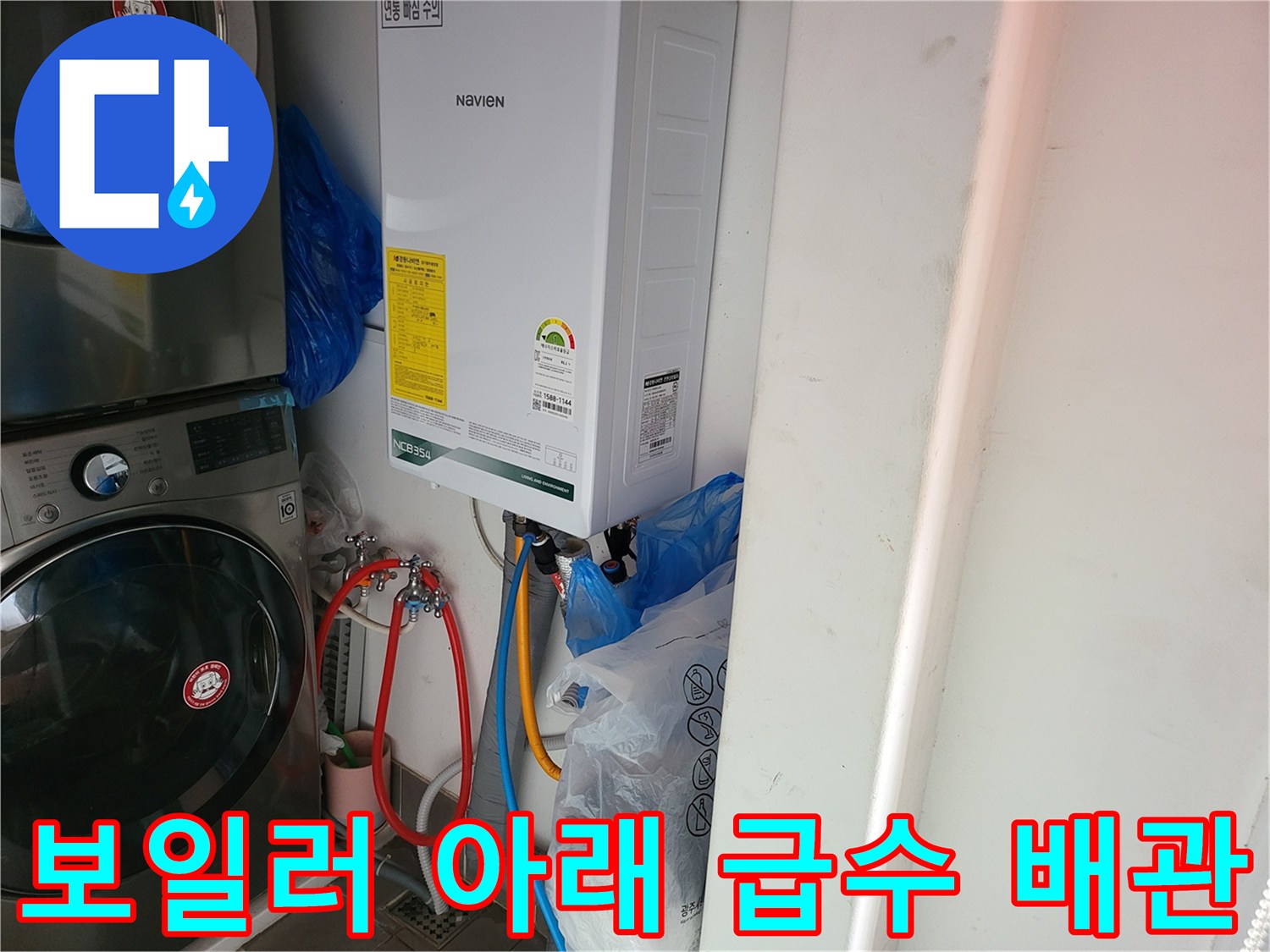 보일러 하단에 연결된 빨간색과 파란색 수도 호스 상세