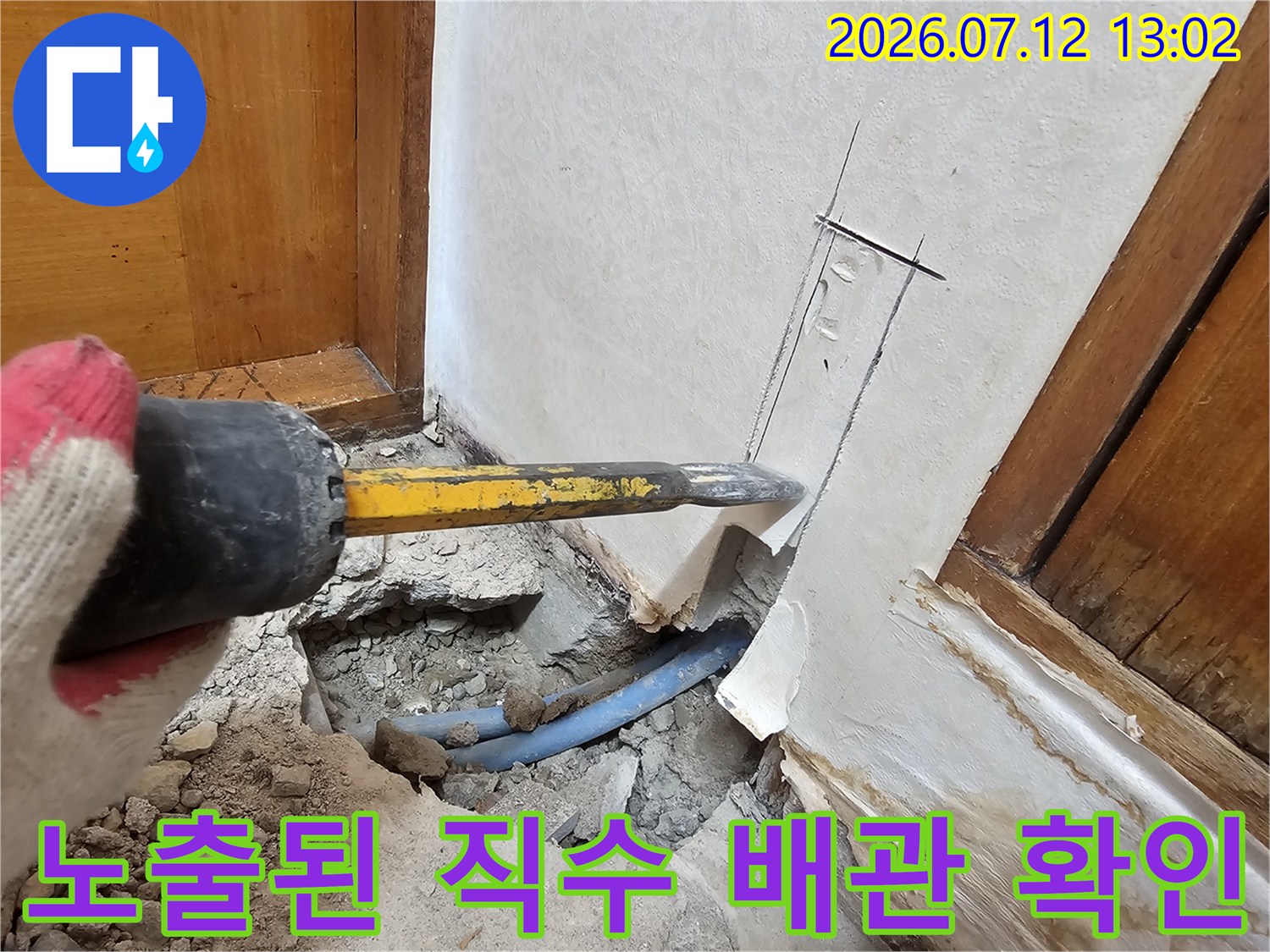벽면 파손 부위에서 노출된 파란색 수도 배관의 모습