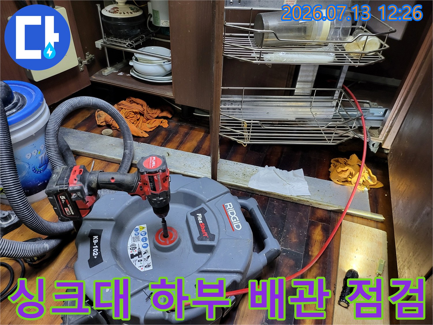 내시경 장비를 연결하여 싱크대 아래 배수구를 세밀하게 조사하는 장면