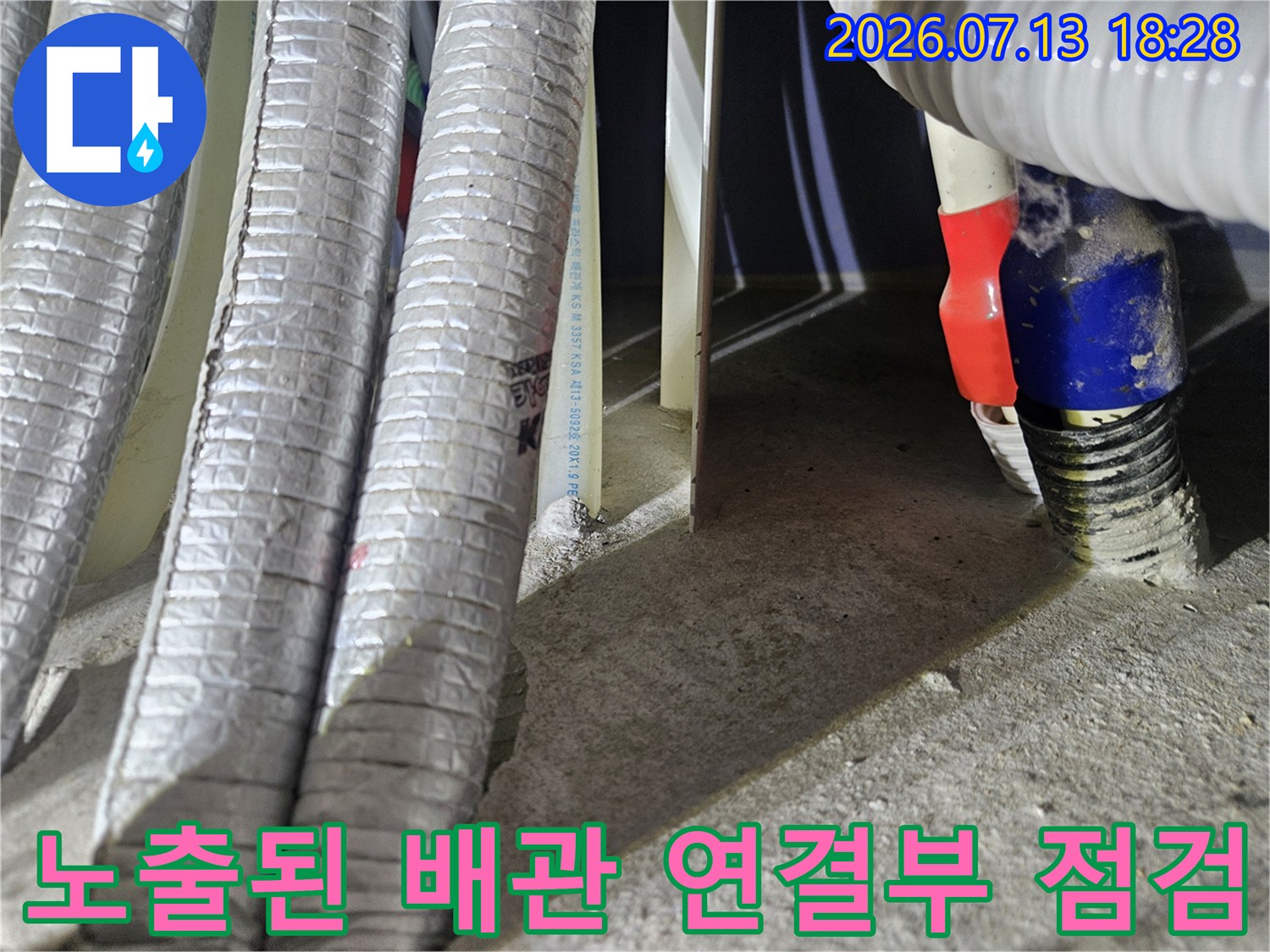 은색 단열재로 감싸진 배관과 파란색 배관 연결 부위의 점검 모습
