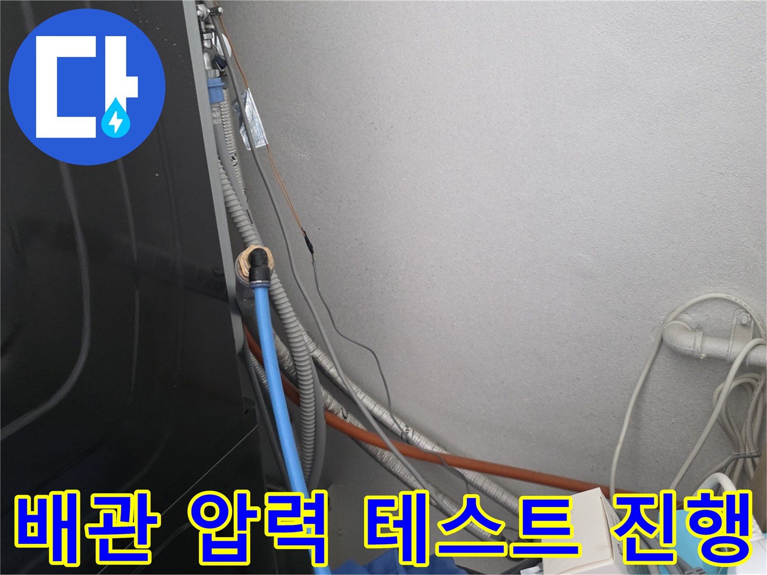 벽면 배관부의 공압 검사용 호스 연결 상태를 보여주는 사진