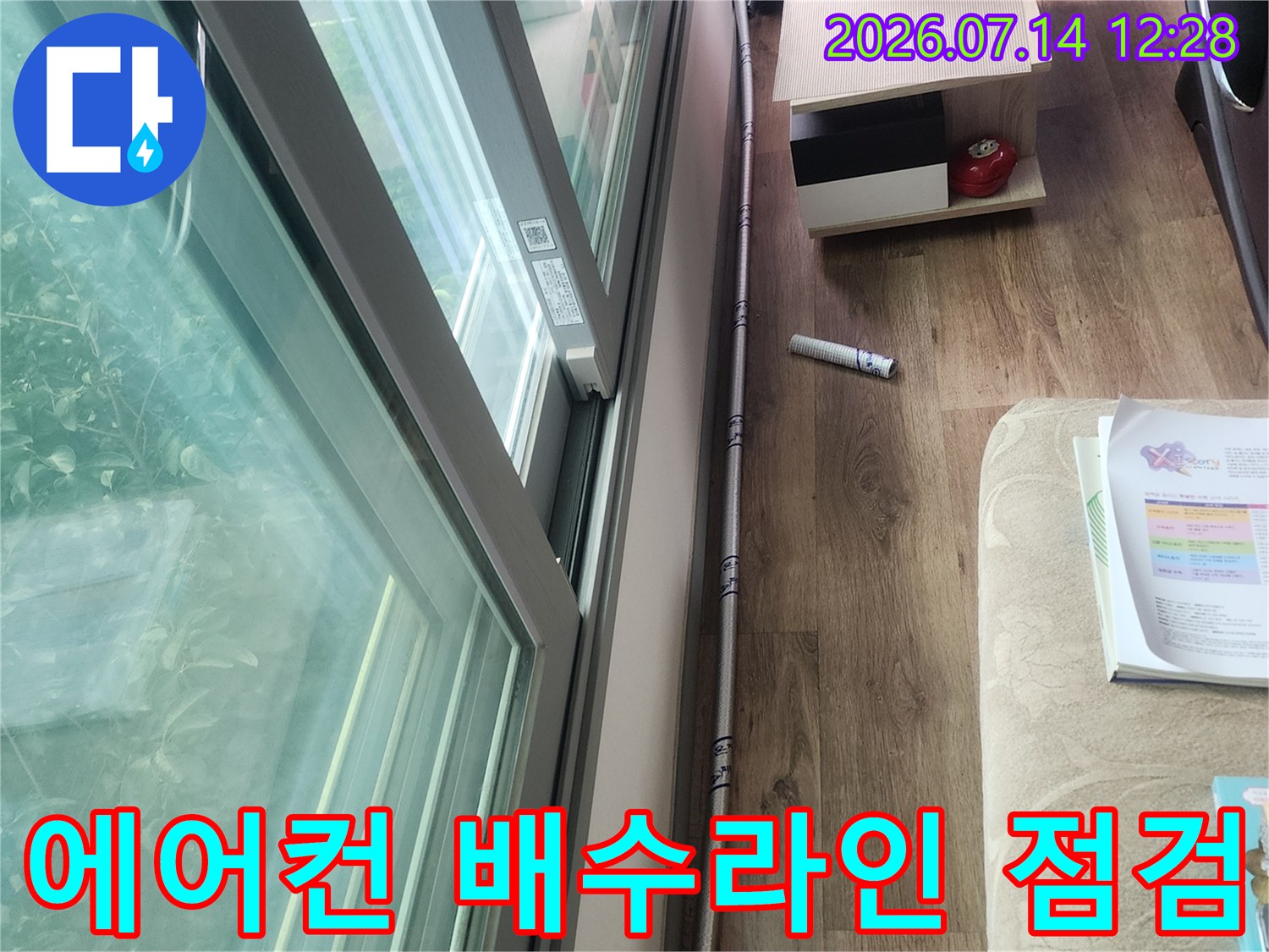 베란다 경계 부위의 에어컨 드레인관을 세밀하게 관찰하는 전문가의 시점