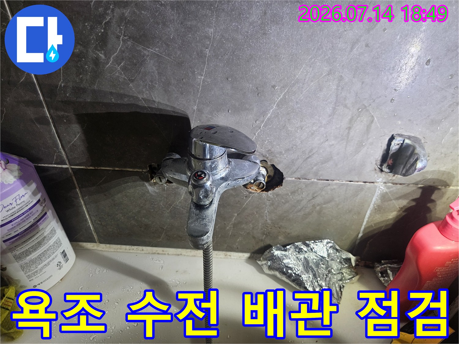 욕조 수전 주변 타일이 파손된 상태에서 노출된 배관 연결부의 모습