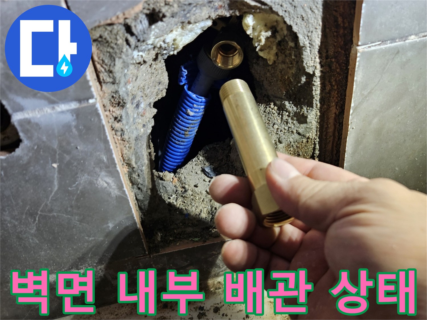 타일을 제거한 벽면 안쪽의 파란색 배관과 수전 연결 부위 모습