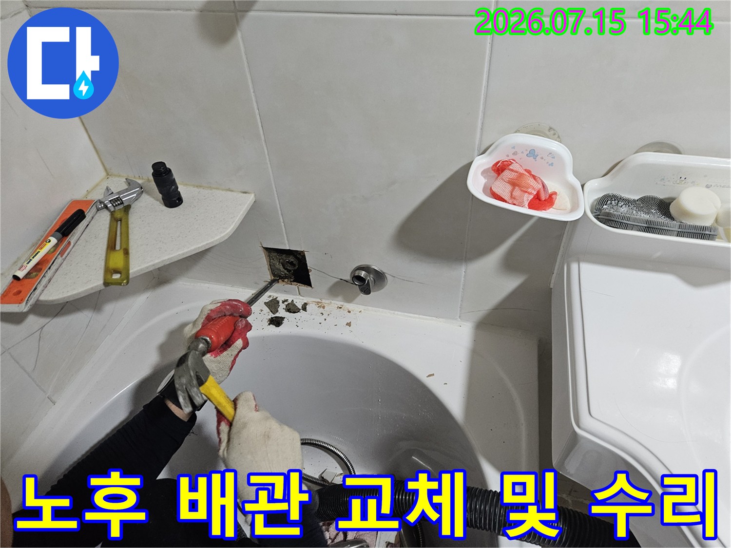 기술자가 세면대 아래 노출 부위의 배관을 공구로 보수하는 모습