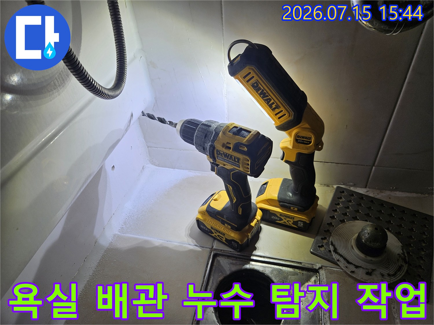 욕실 바닥 하수구 근처에서 전문 장비를 사용하여 배관 누수 지점을 정밀하게 탐지하는 모습