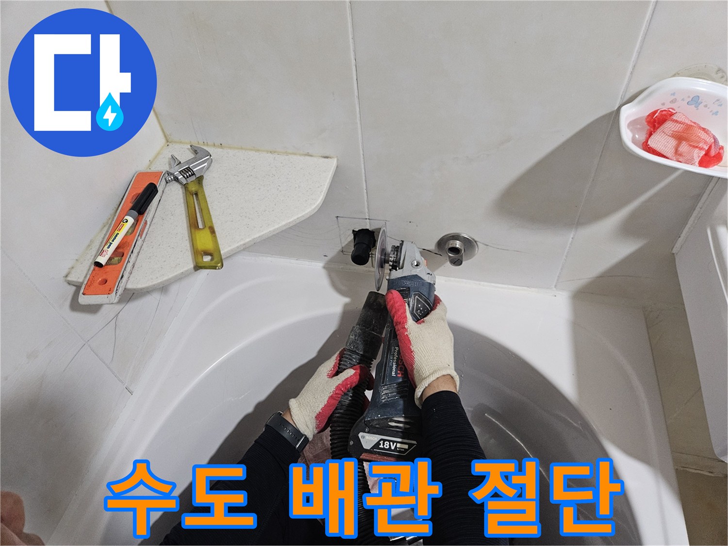 화장실 벽면-누수 지점의 배관을 자르는 공구와 작업자의 손