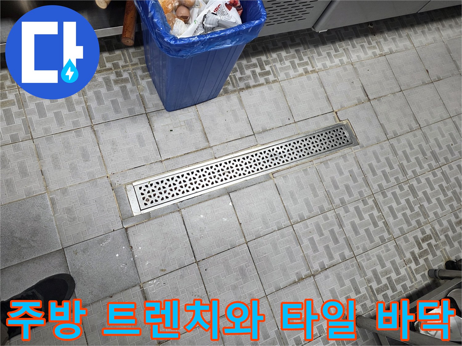 식당 주방의 스테인리스 배수 시설과 회색 타일 현장