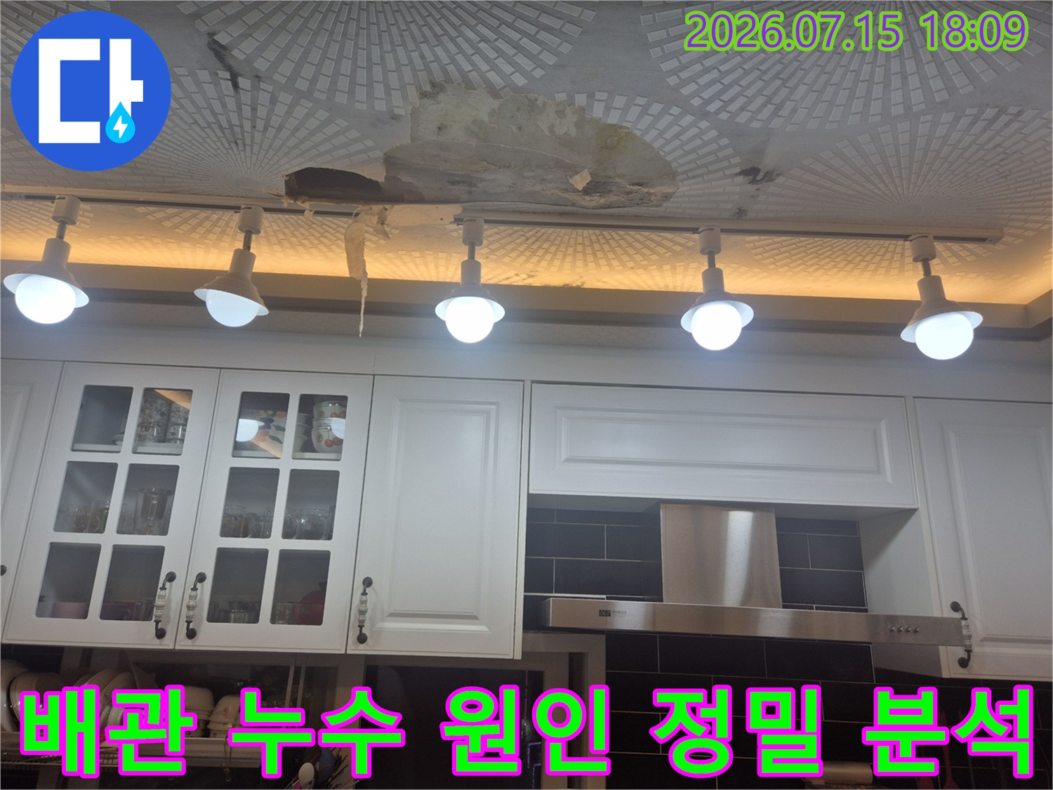 주방 천장 조명과 마감재가 훼손된 상태에서 배관계통을 집중 점검하는 모습