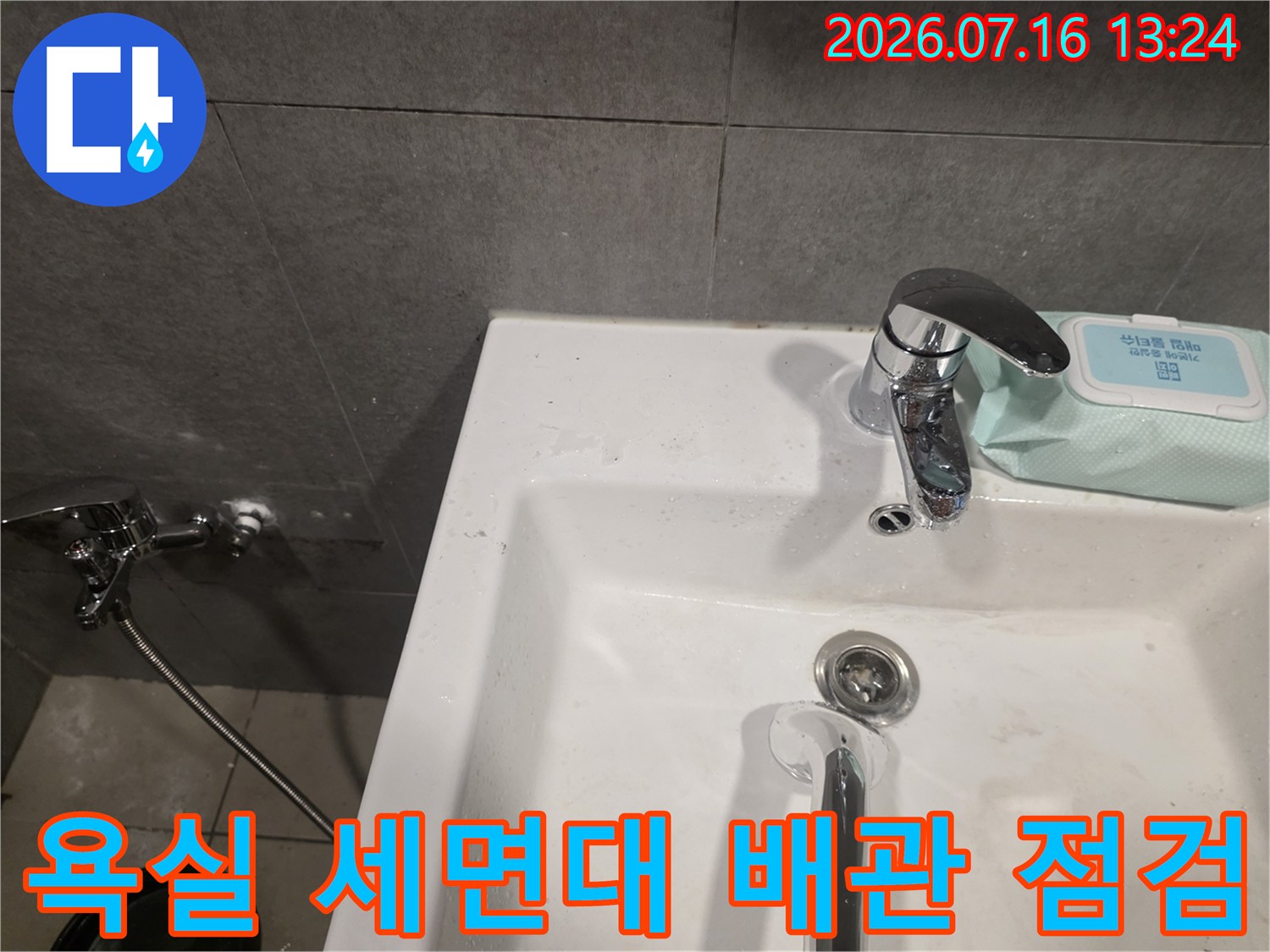 세면대 하부 배관과 수전이 설치된 욕실 내부 모습