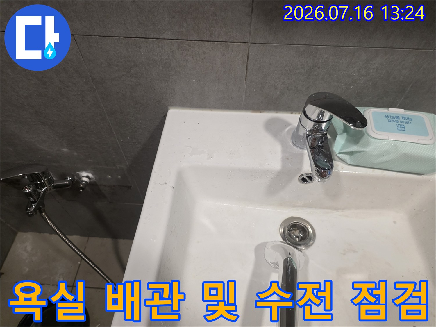 흰색 세면대에 설치된 크롬 도금 수전과 하단 연결부 상세 모습