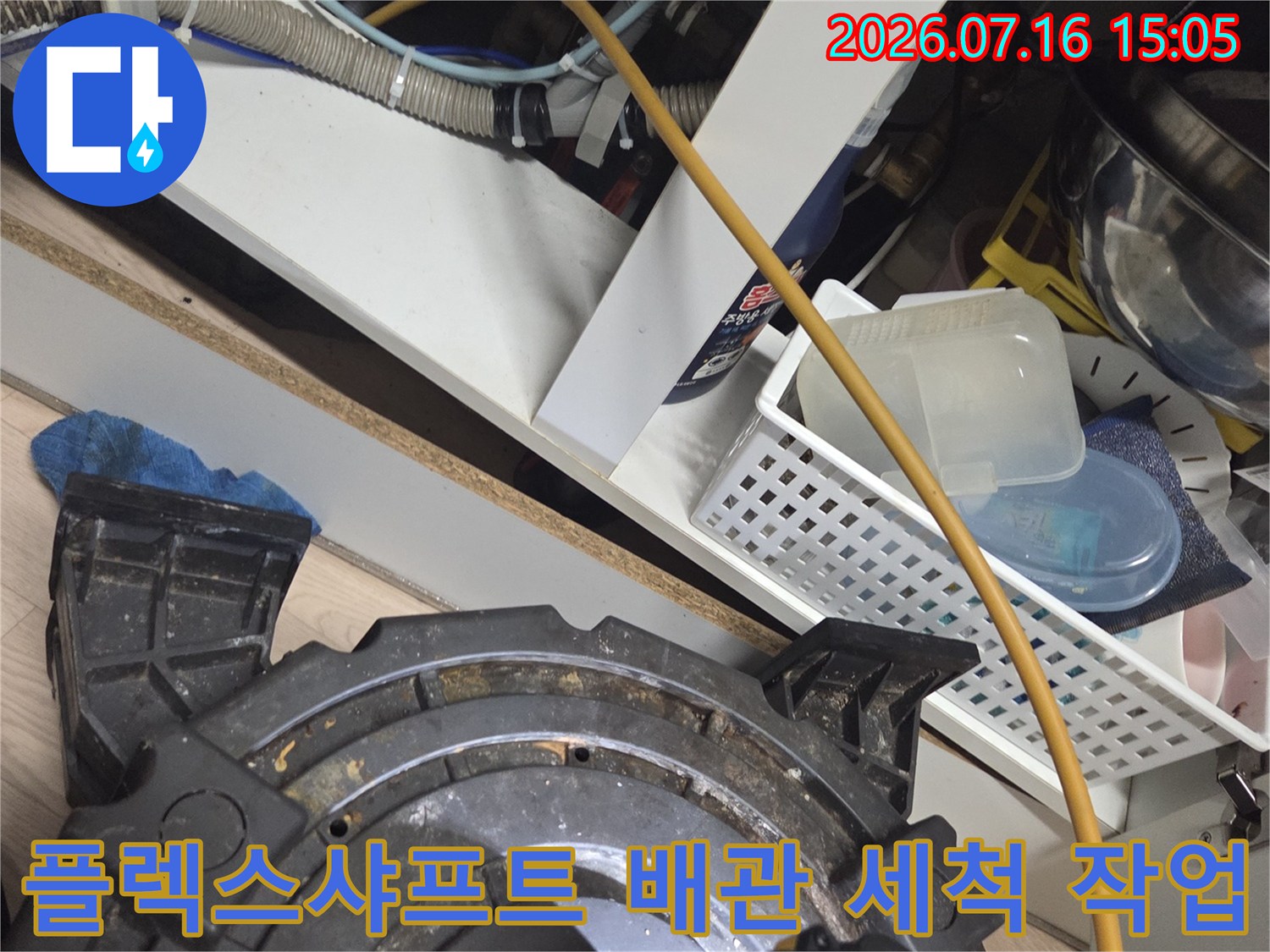 전용 샤프트 장비를 활용하여 싱크대 하부 배수관 내부의 슬러지를 제거하는 모습