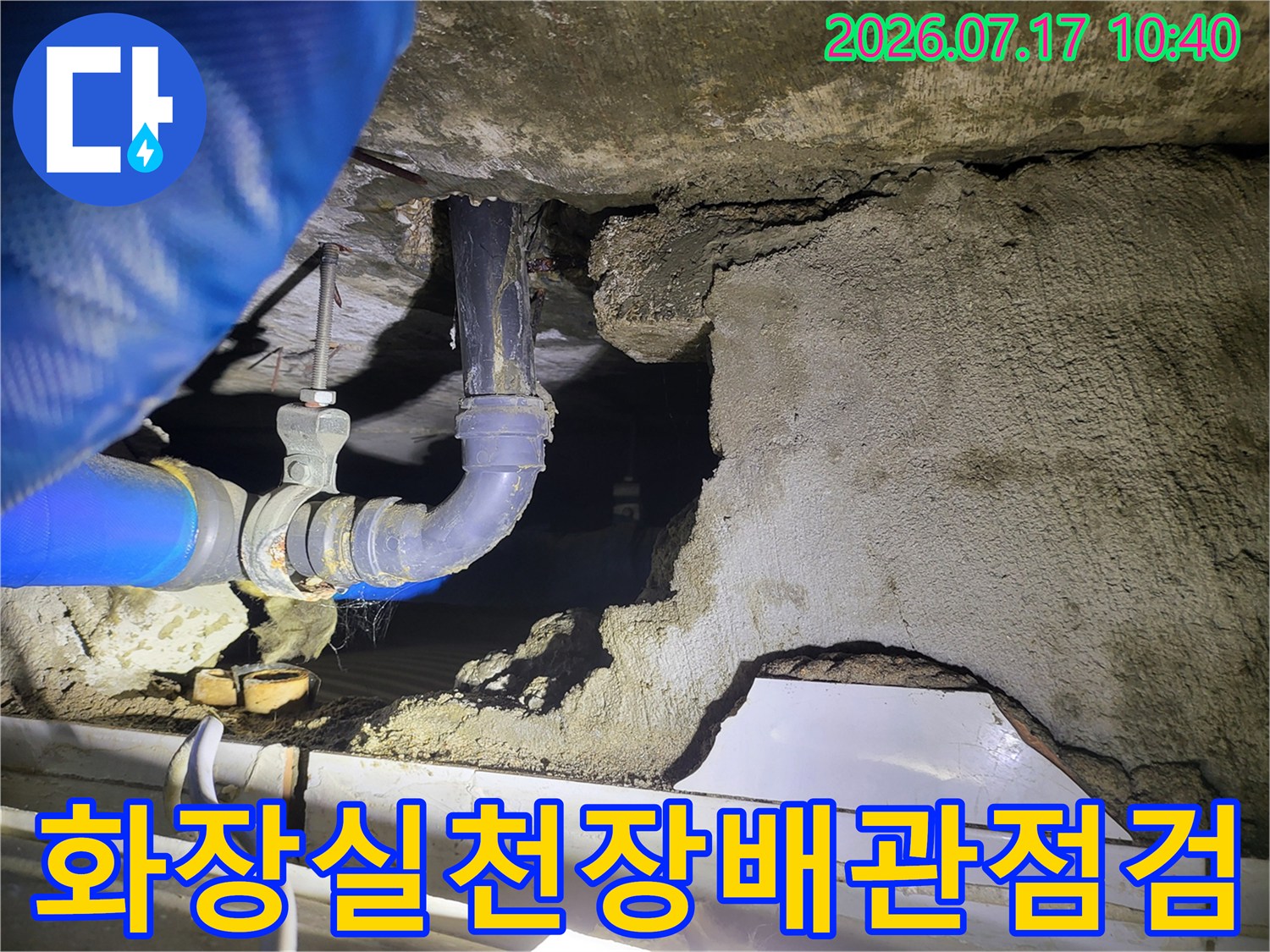 천장 내부의 노출된 배관과 압력 점검용 장비가 연결된 모습