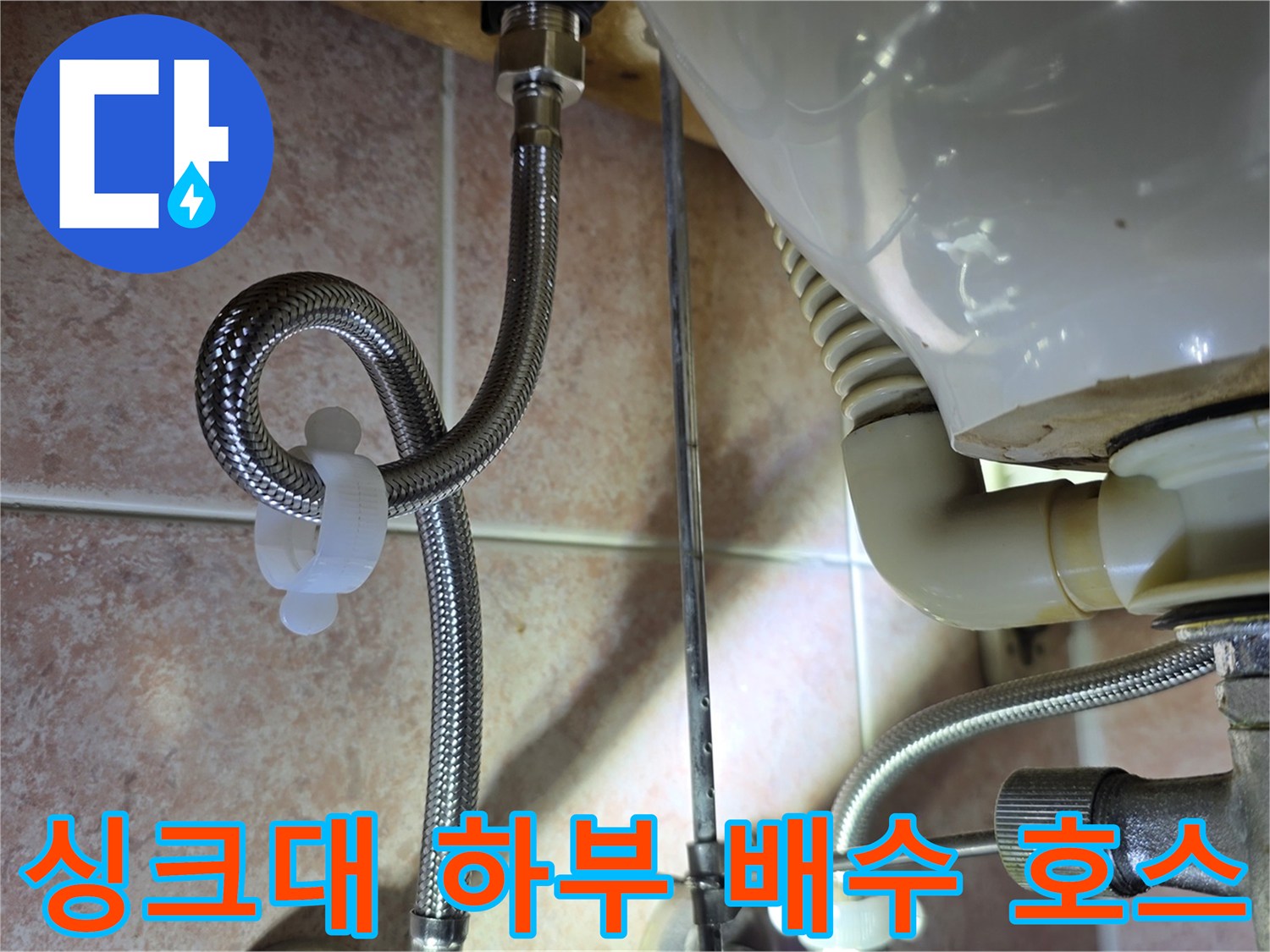 주름진 은색 호스와 굵은 배관의 연결 지점 근접 촬영