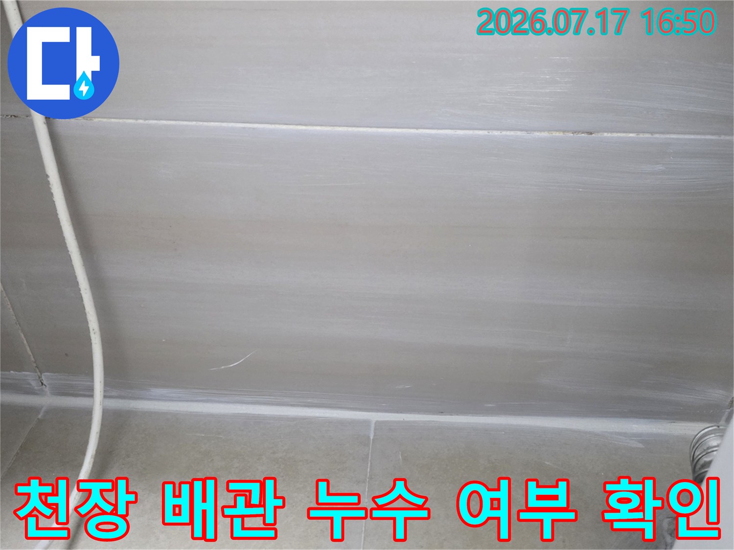 천장 내부를 점검하며 배관 주변을 조사하는 모습