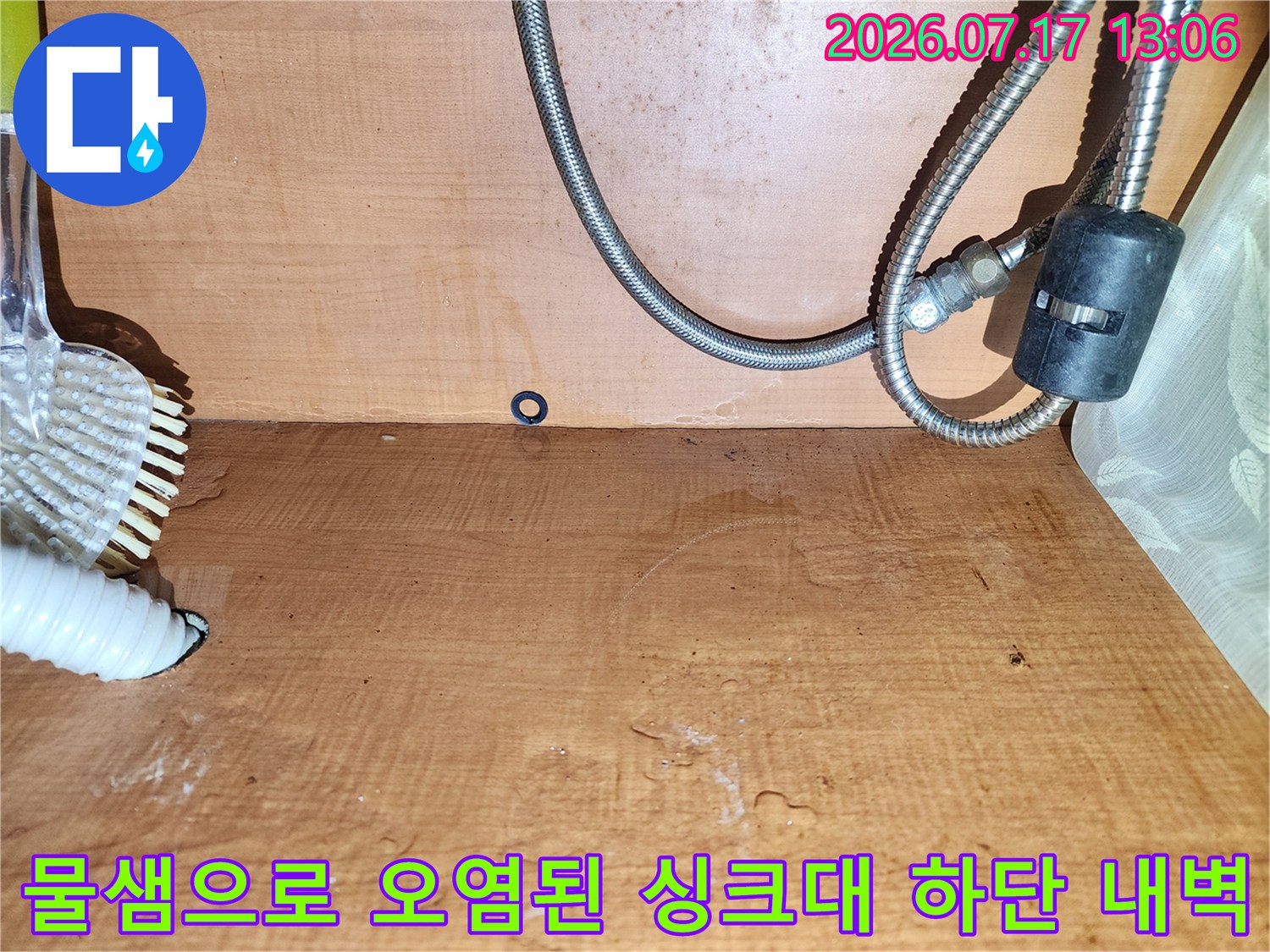 금속 및 플라스틱 배관이 설치된 주방 싱크대 내부-벽면 목재의 누런 물 얼룩