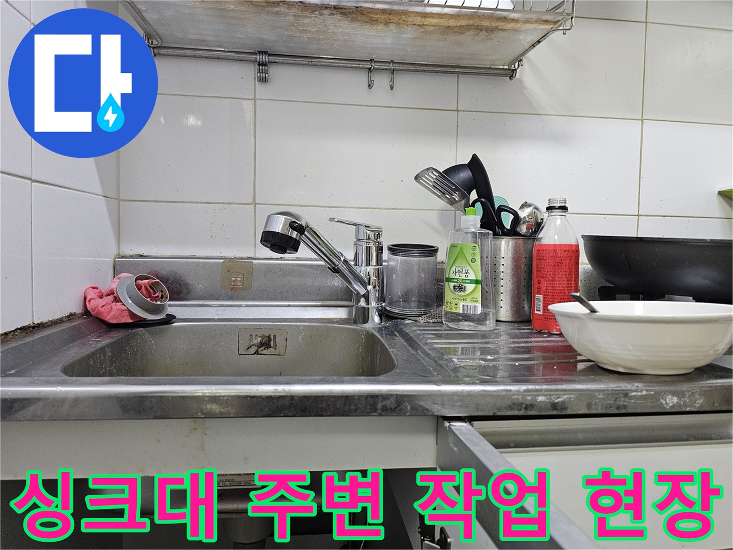 싱크대 수전과 청소 도구가 놓인 주방 모습